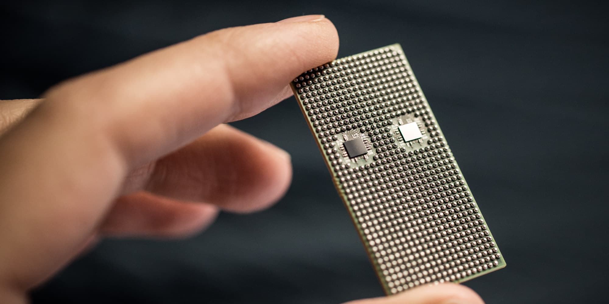 imec-79GHz-radar-chip_1 Hand holding a semiconductor chip package with two small square dies and a grid of solder balls