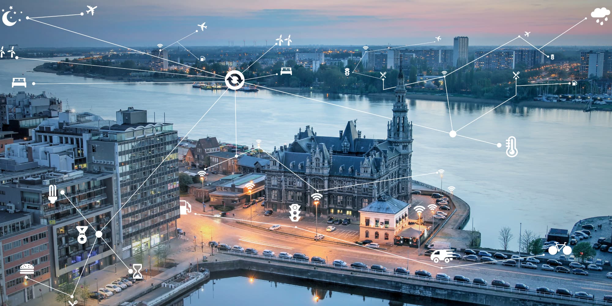 imec-antwerp-city-of-things_1 Aerial view of Antwerp at dusk with connected smart city icons over the skyline and river