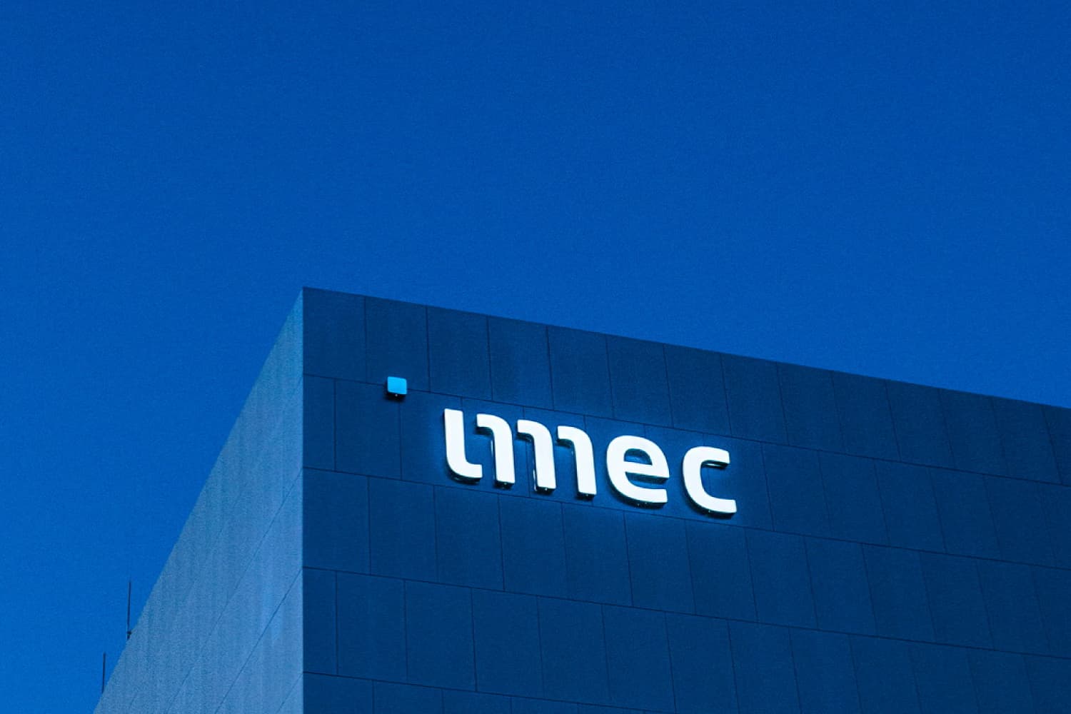 imec-cleanroom-logo_1 imec logo on the exterior of a modern building against a blue sky