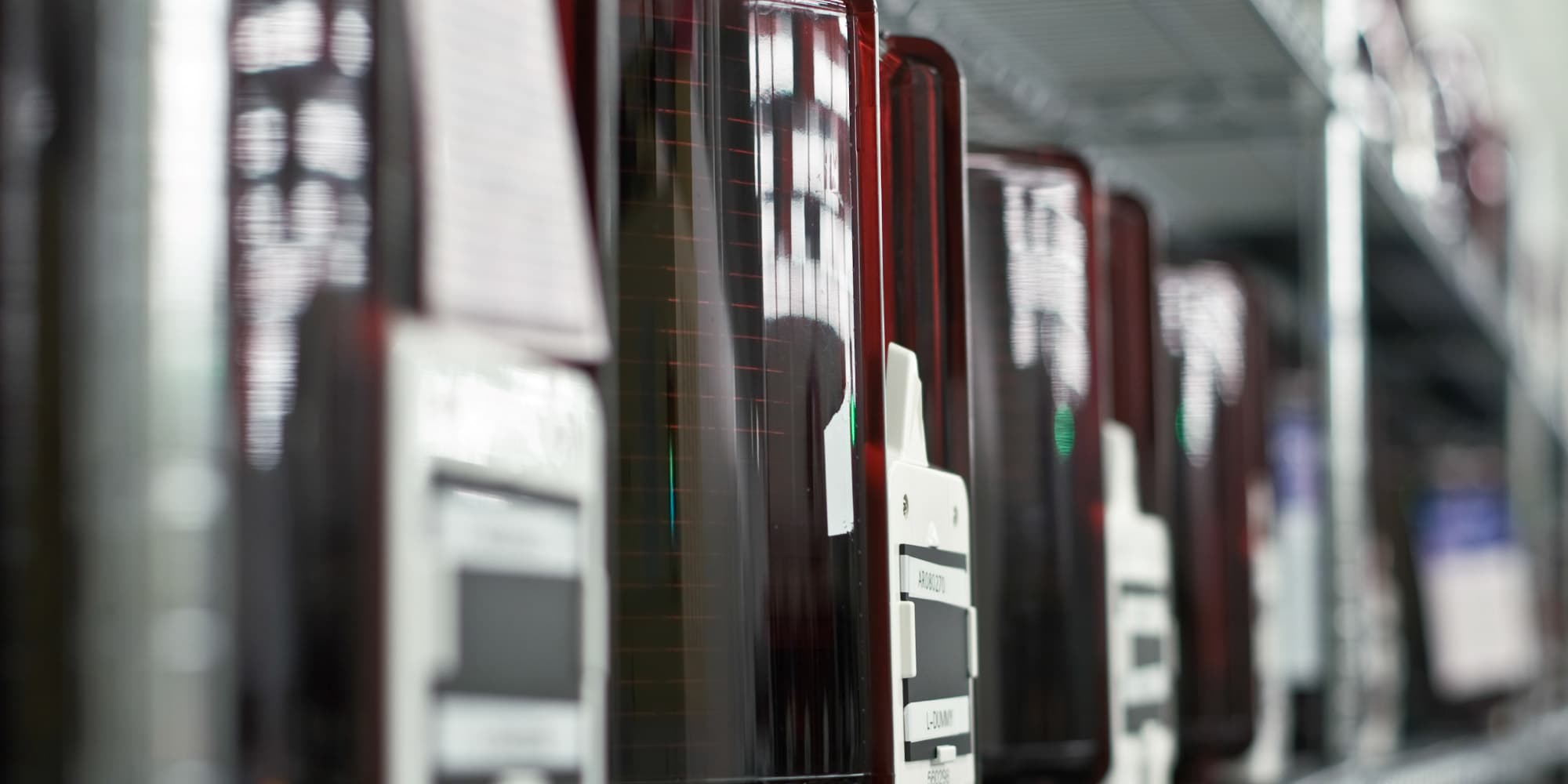 Imec%E2%80%99s-extremely-scaled-SOT-MRAM-devices-show-record-low-switching-energy-and-virtually-unlimited-endurance Rows of semiconductor test modules in a lab corridor, with one unit in sharp focus and others blurred behind it.