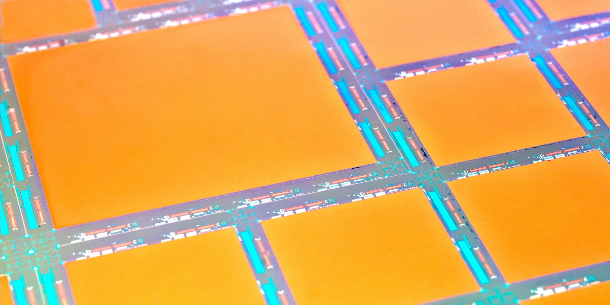 imec_expertise_image_sensors_and_vision_systems_1 Close-up of a semiconductor wafer with orange rectangular sensor areas and circuit lines