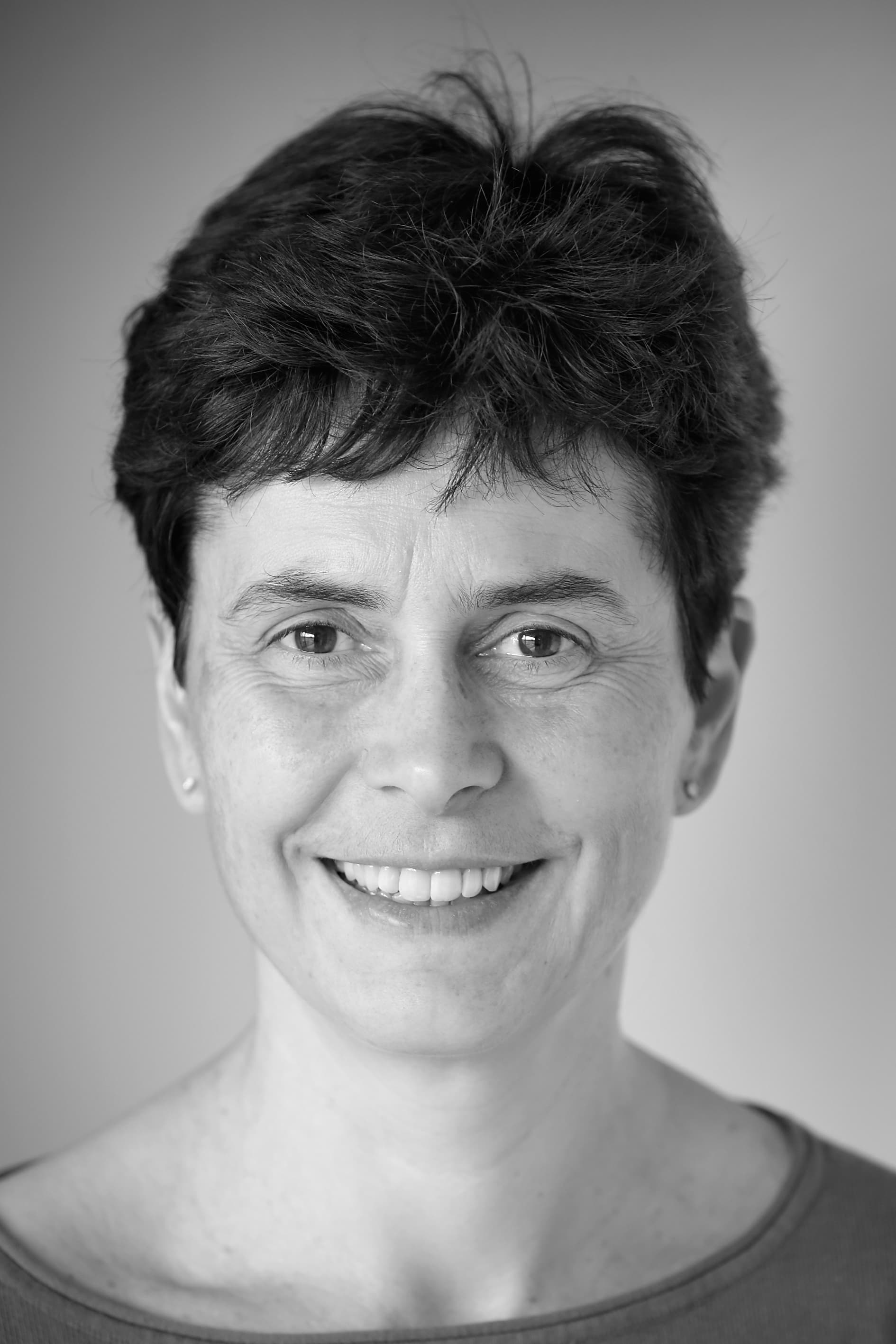 imec_ingrid_verbauwhede_bio_1 Black-and-white headshot of Ingrid Verbauwhede smiling against a plain background