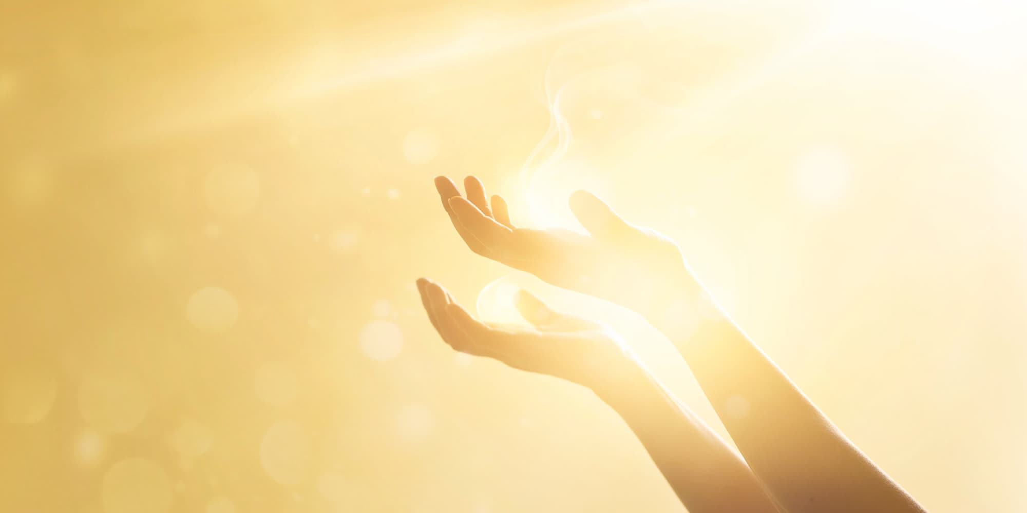 imec-magazine-10-photonics_1 Two outstretched hands reaching toward bright golden light with a soft lens flare