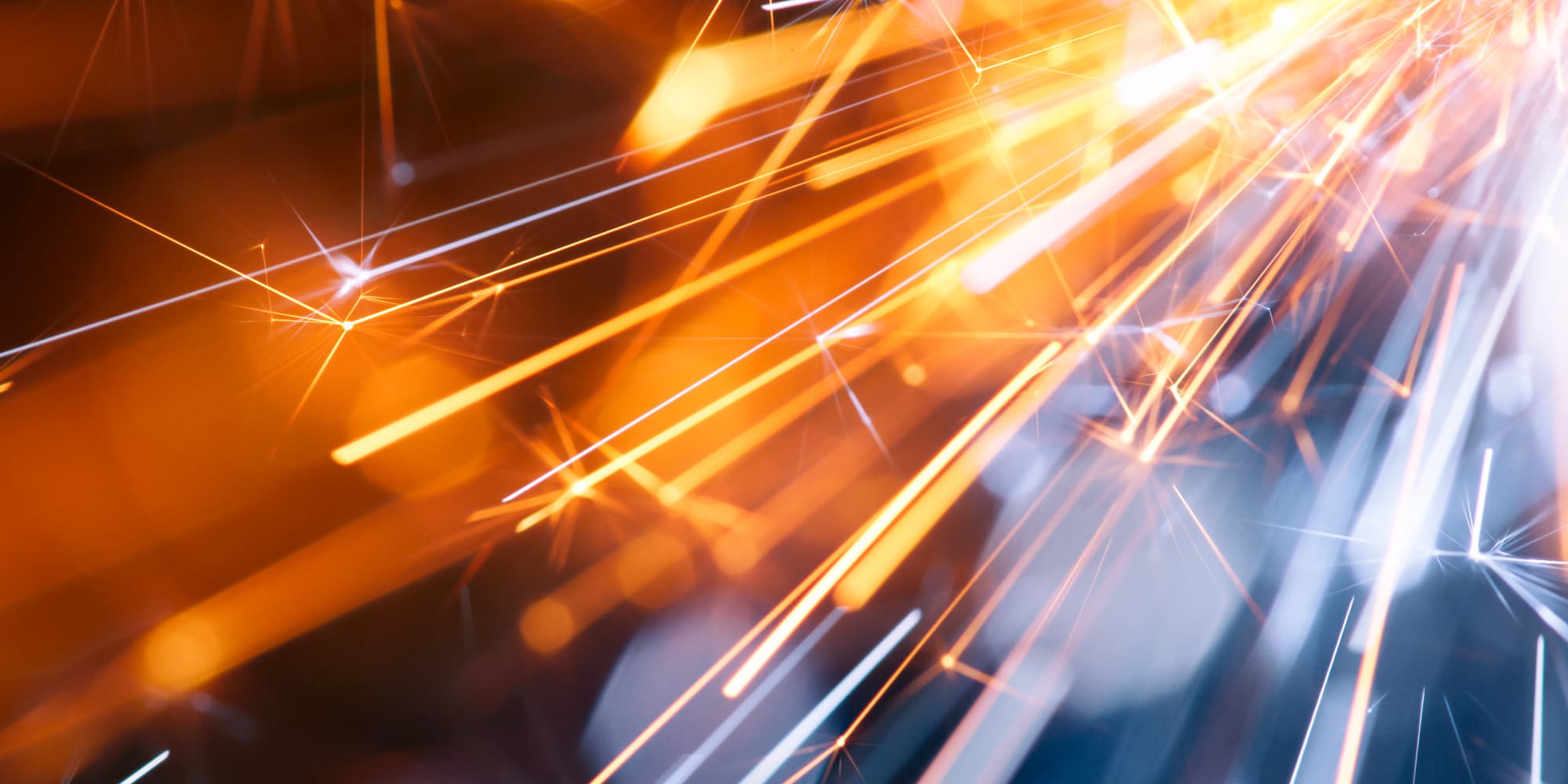 imec-magazine-ai-special-03_edge-ai_1 Abstract orange and blue light streaks suggesting high-speed data and edge AI