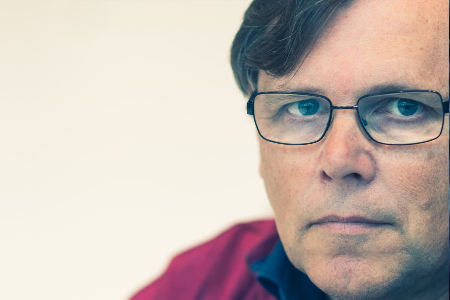 imec-magazine-c-01-eric-beyne_1 Close-up portrait of Eric Beyne wearing glasses against a light background.