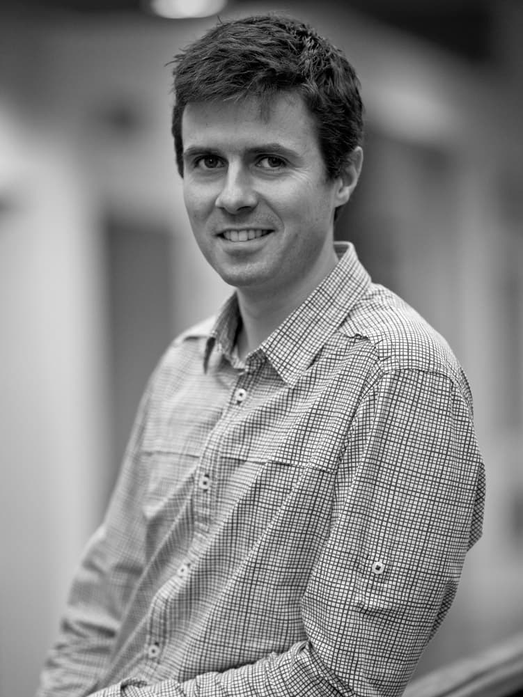 imec-magazine_Pol-Van-Dorpe_bio_1 Black-and-white portrait of Pol Van Dorpe smiling in a checkered shirt