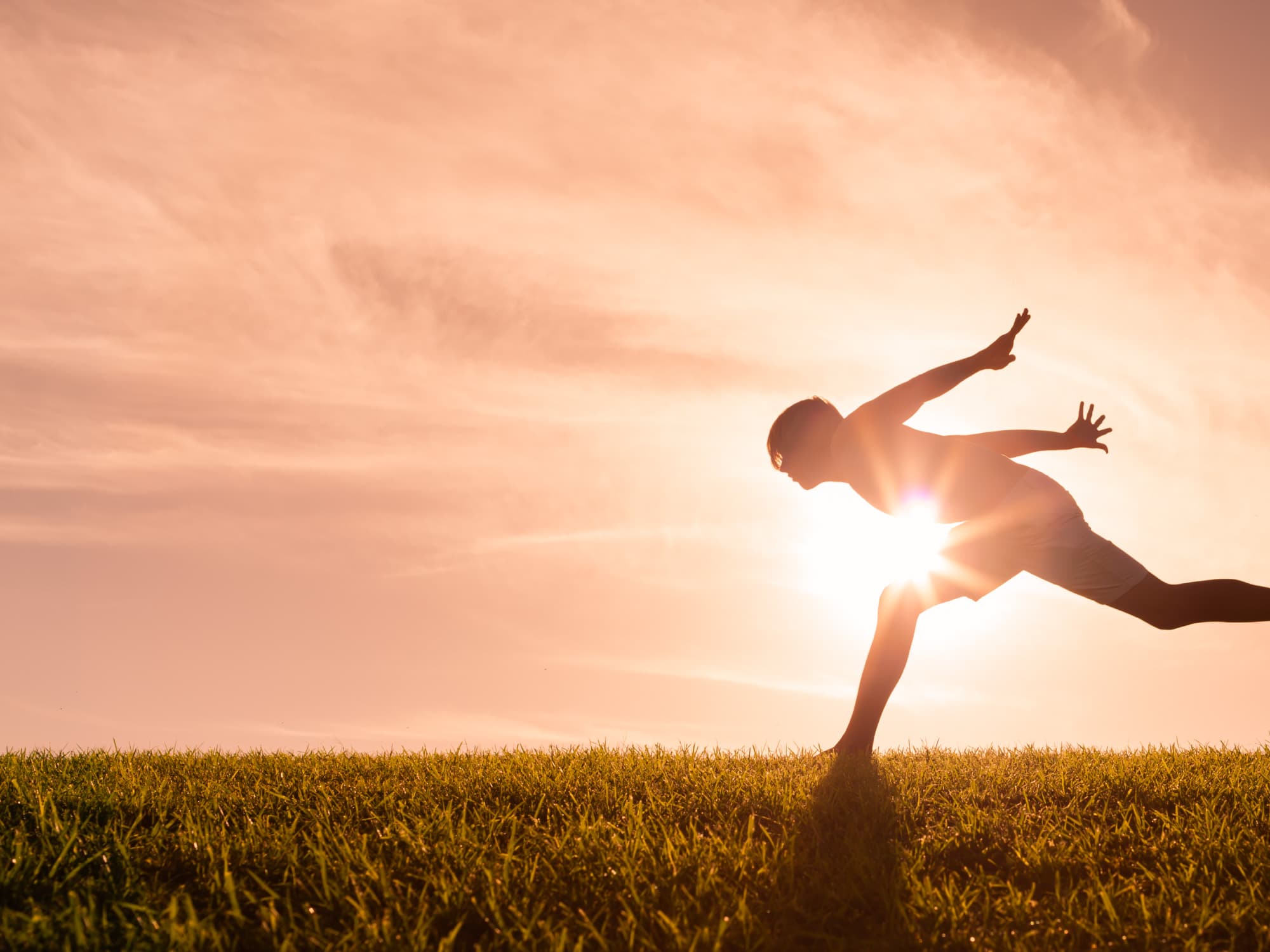imec-magazine-smart-energy-header_1 Silhouetted person balancing on one leg in a grassy field at sunset