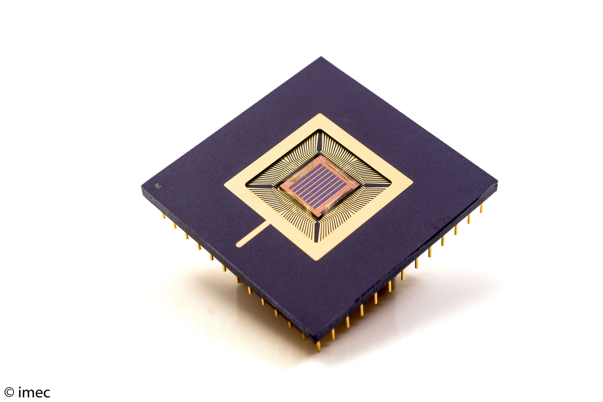 imec-neuromorphic-self-learning-chip_1 Neuromorphic chip package with a square central die and gold pins on a white background