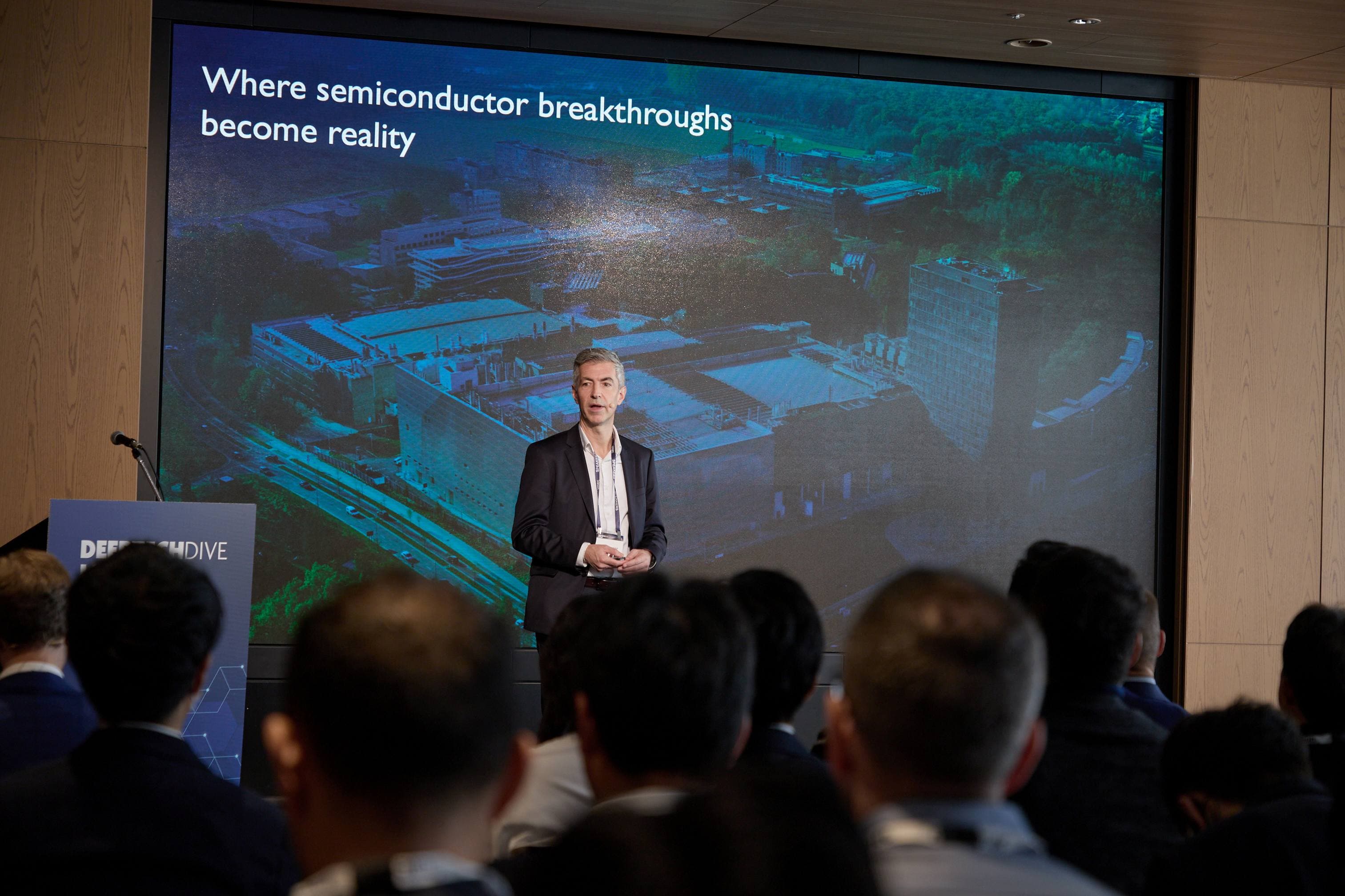 imec.venturing%20event Speaker presenting at a venturing event in front of a screen reading 'Where semiconductor breakthroughs become reality'