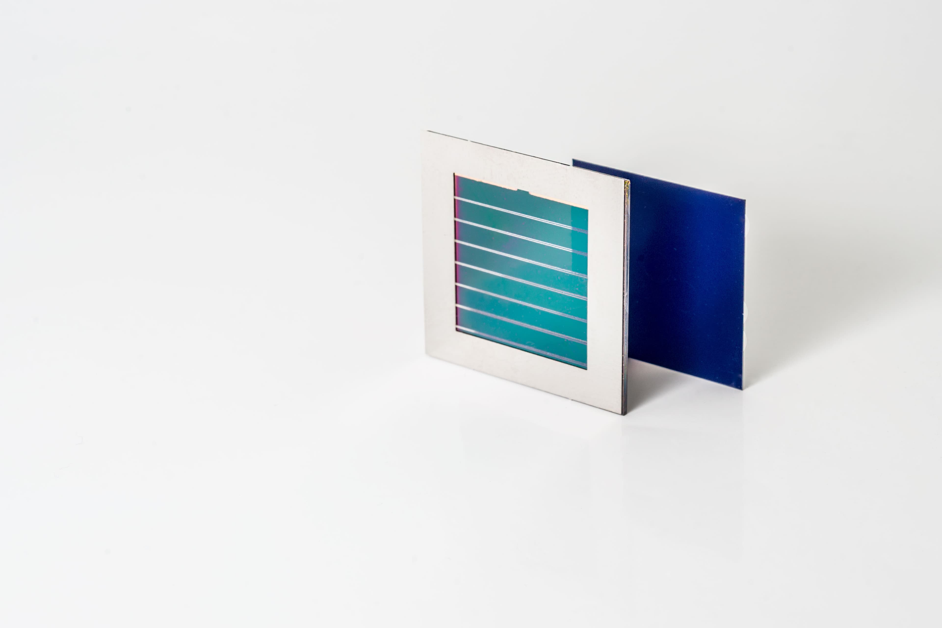 imecperovskiteSitandem_1 Perovskite-silicon tandem solar module on a white background, shown as two stacked square cells