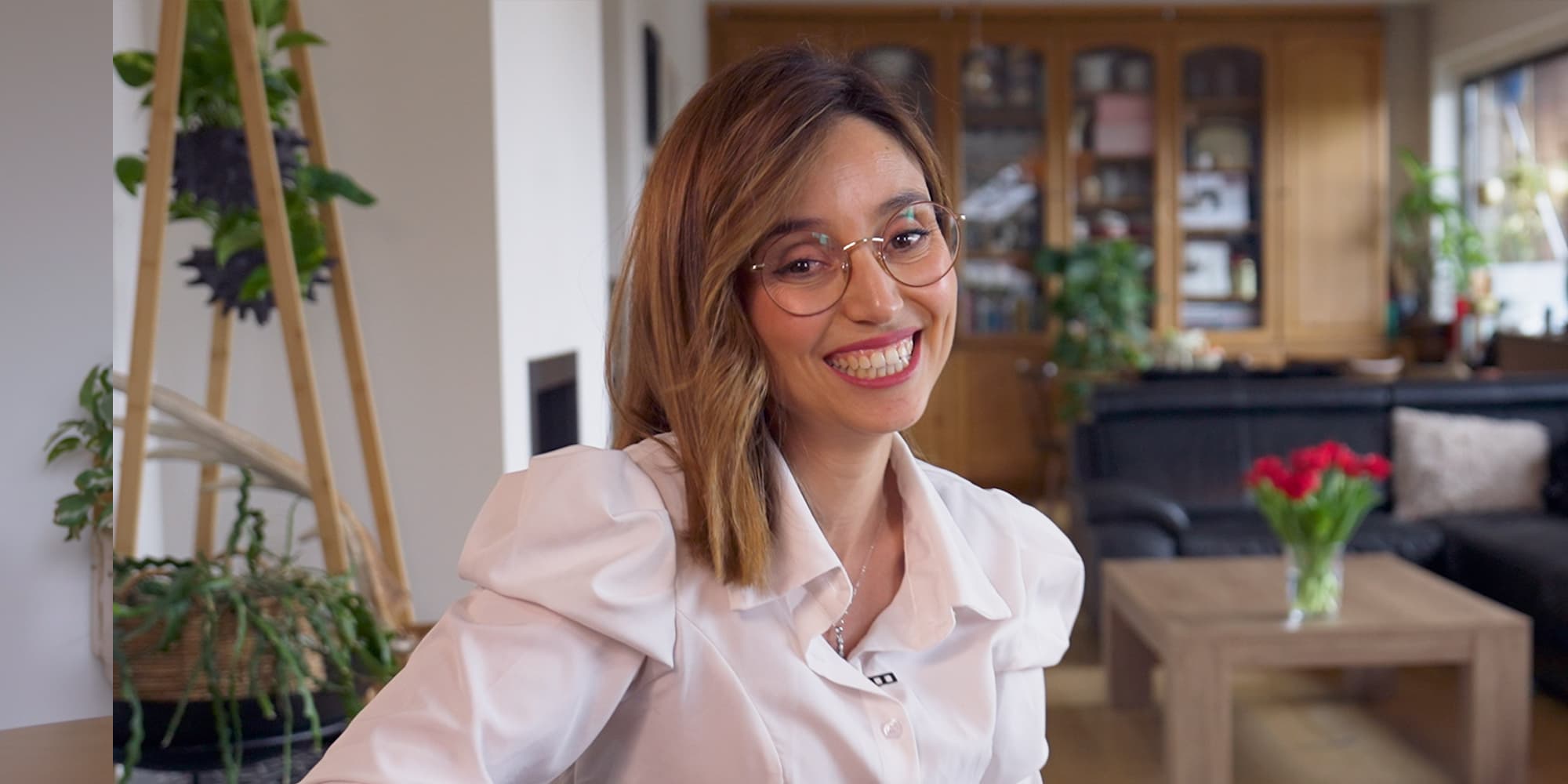 Imene-Jadli Smiling woman with glasses in a home-like office setting