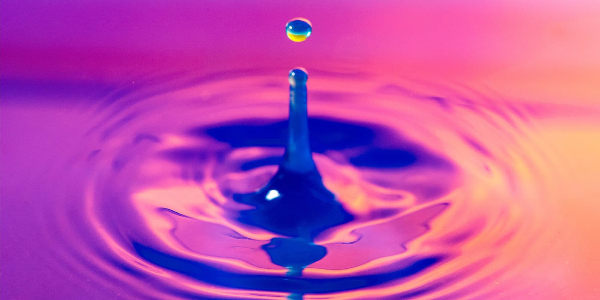 internet_of_water Blue water droplet splashing into a pink and purple pool, creating ripples