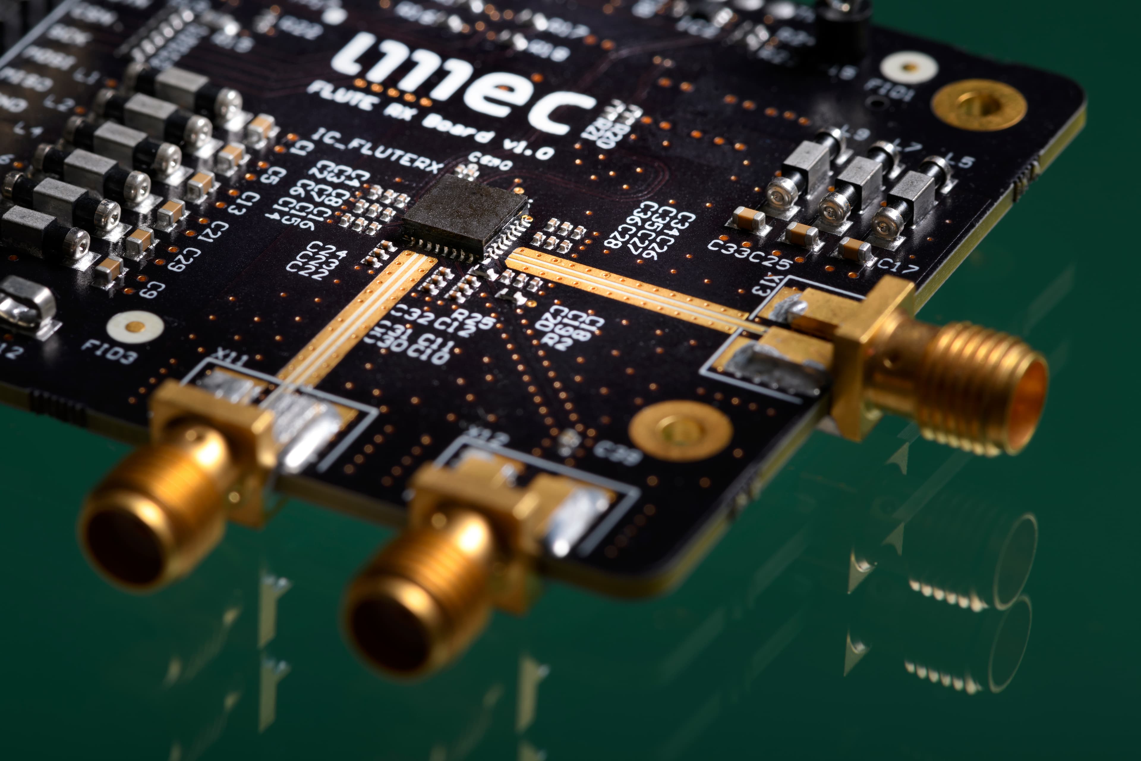 ISSCC%202024_UWB_main%20visual UWB receiver chip mounted on a circuit board with gold connectors and test components