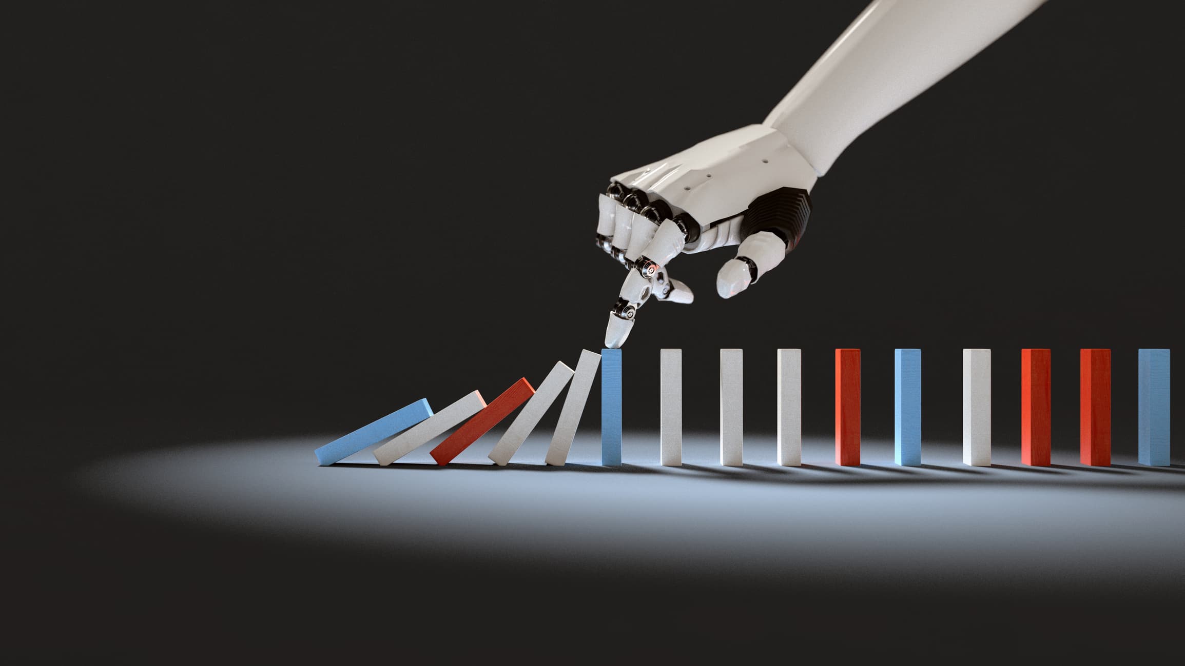 iStock-1169037307 Robothand die de eerste dominosteen in een rij kleurrijke dominostenen omver duwt