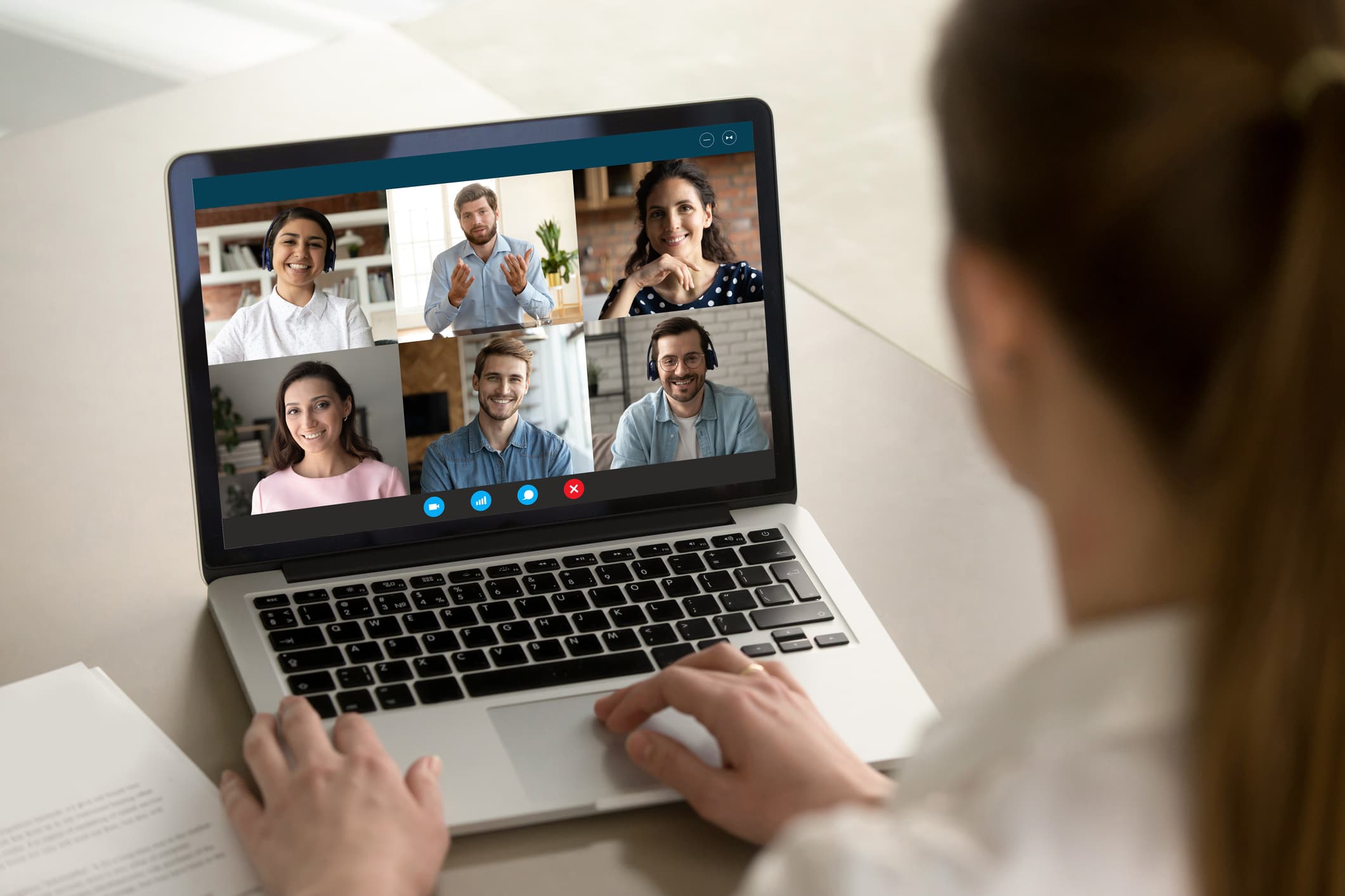 iStock-1282034978 Persoon in videogesprek op een laptop met zes deelnemers in een raster