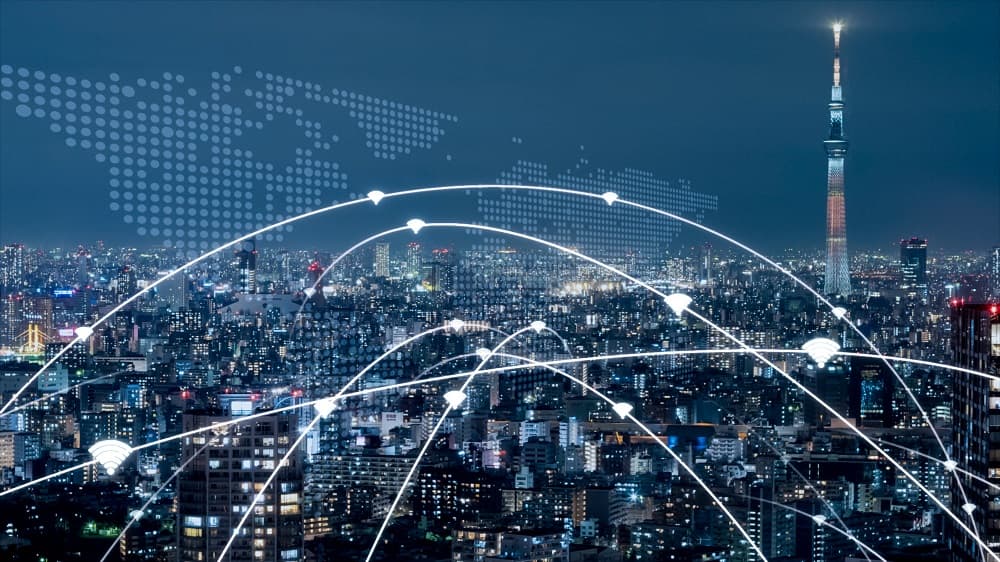 iStock-1312945540 Night city skyline with wireless connection arcs and a glowing tower