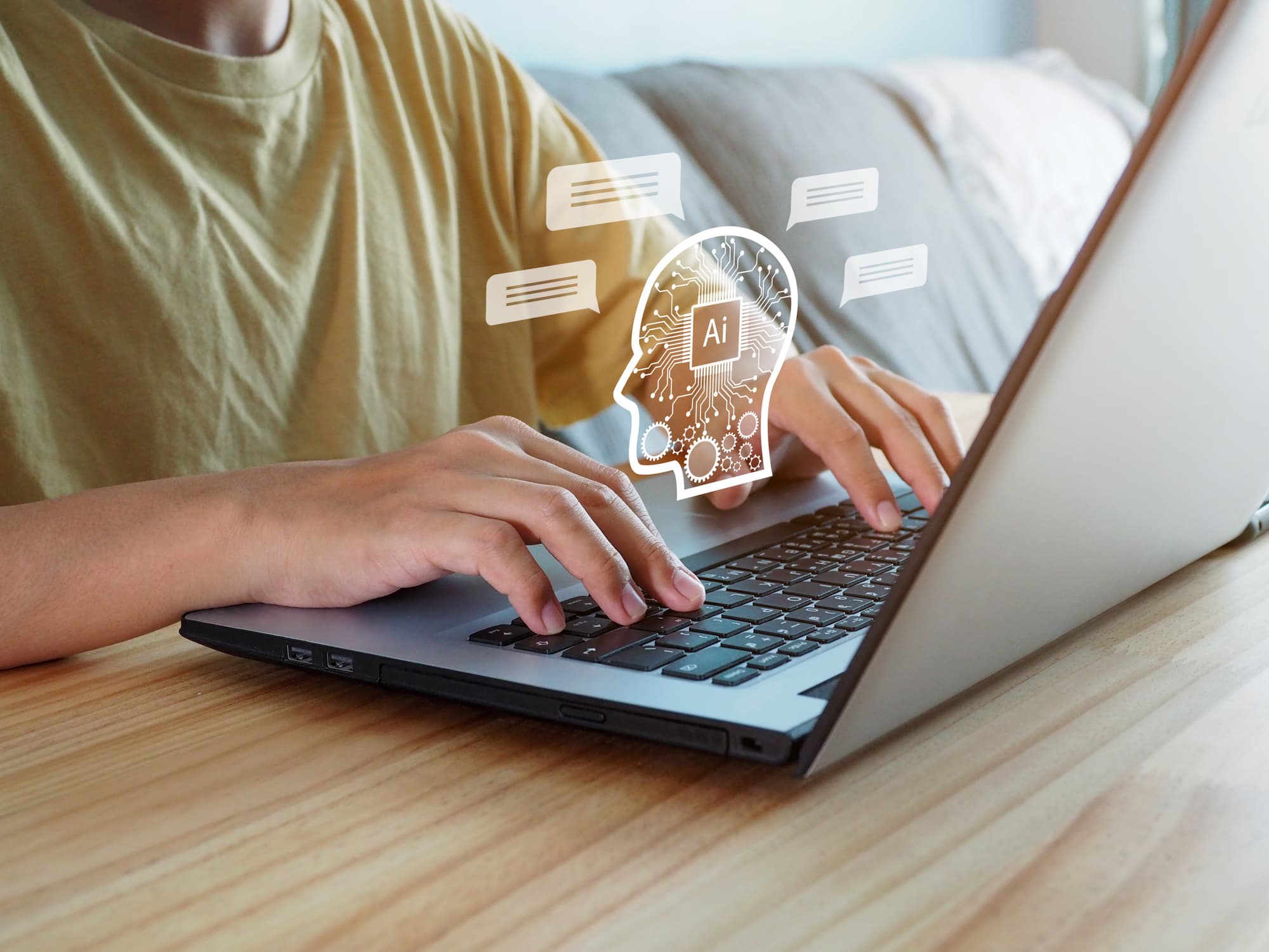 iStock-1467485608 Persoon die typt op een laptop met een AI-chatpictogram eroverheen