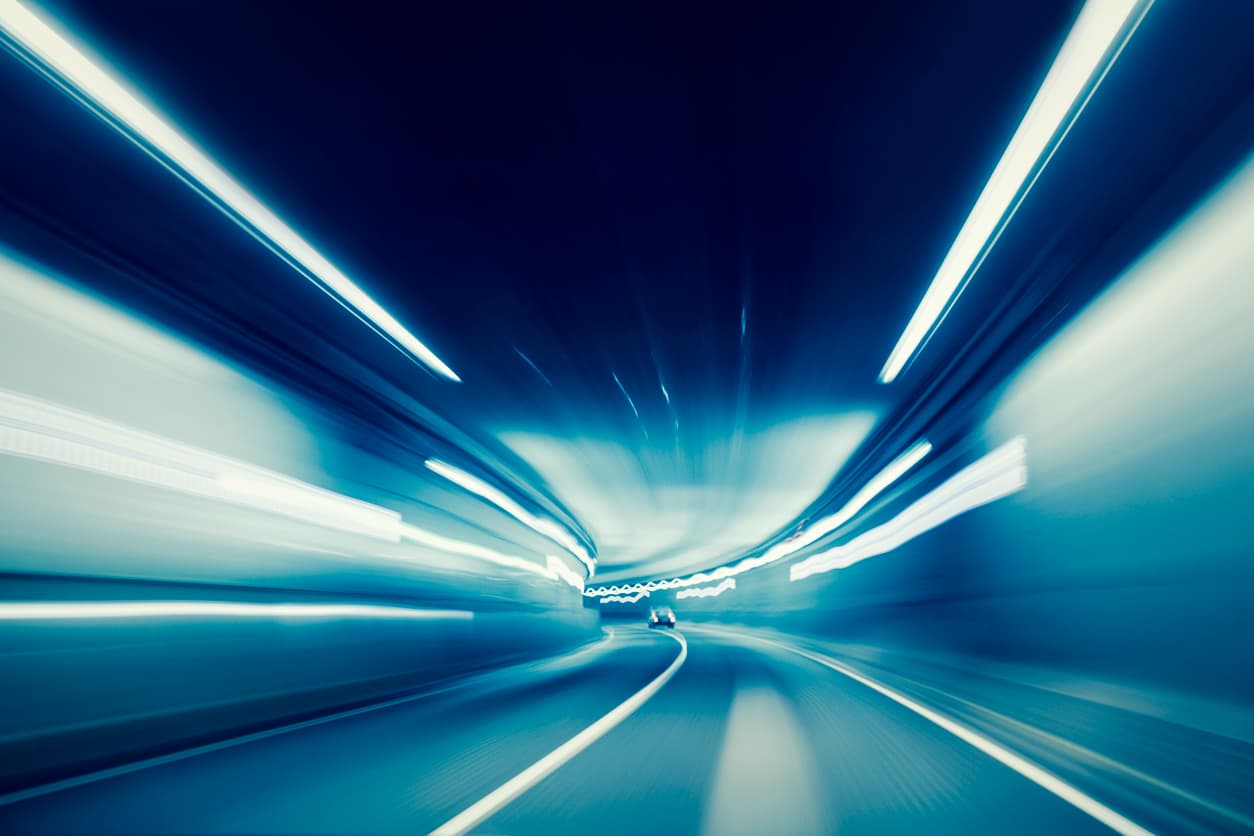 Blurred view driving fast through a highway tunnel Blurred view driving through a lit highway tunnel at speed
