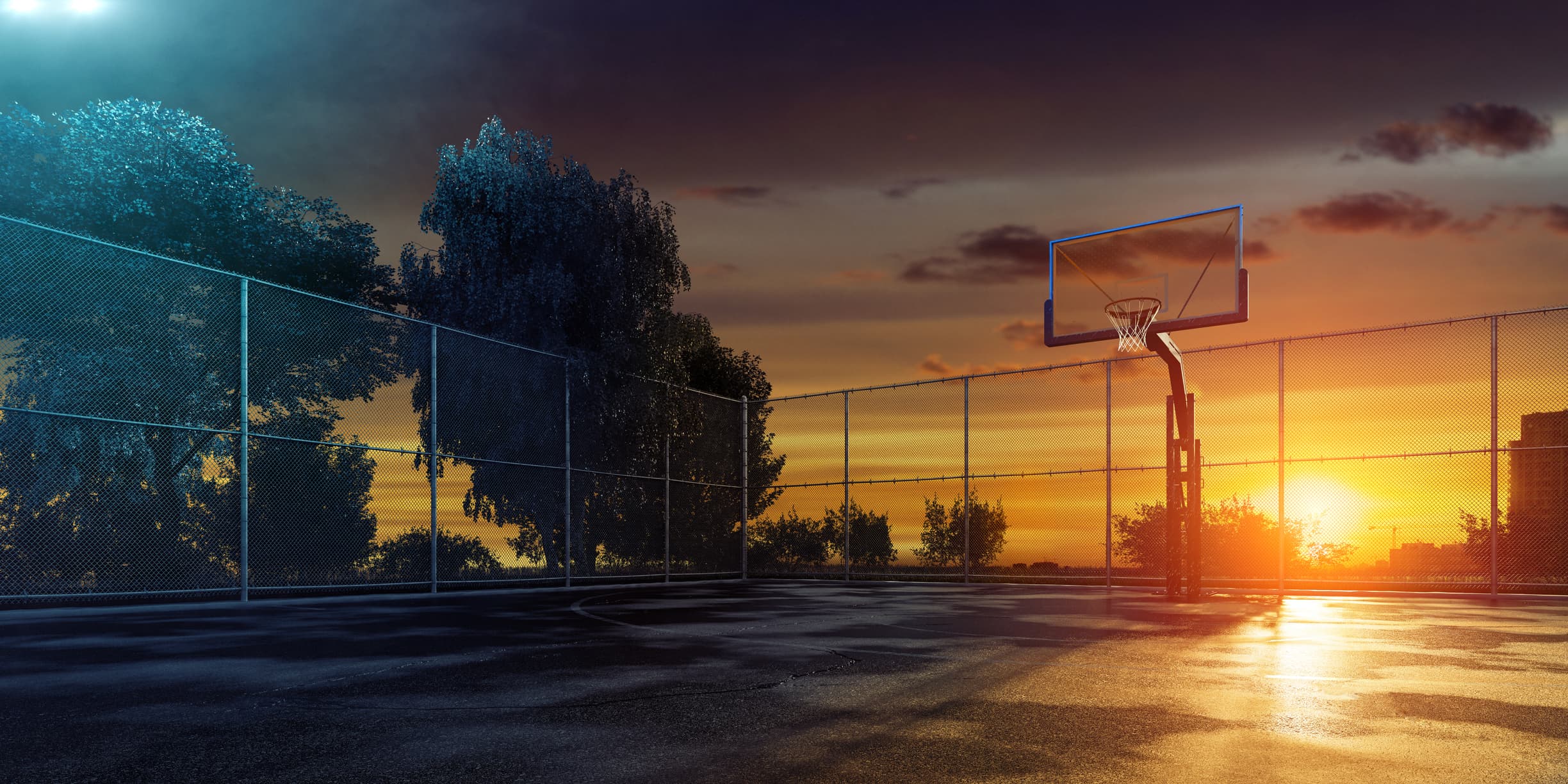 Empty outdoor basketball court at sunset Empty outdoor basketball court at sunset, enclosed by chain-link fencing with a hoop in view