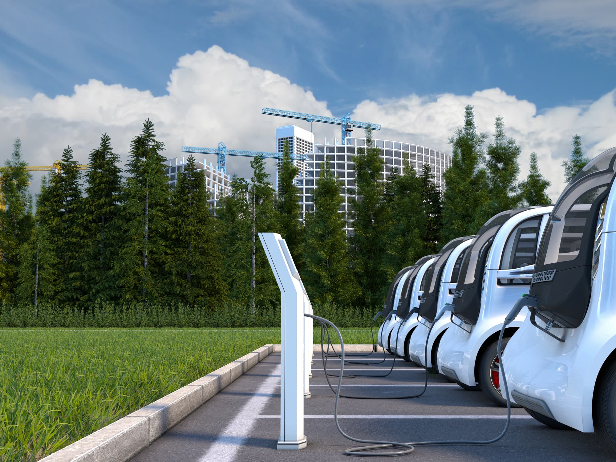 iStock-624698752_0 Electric cars plugged into charging stations in a parking lot with trees and buildings in the background