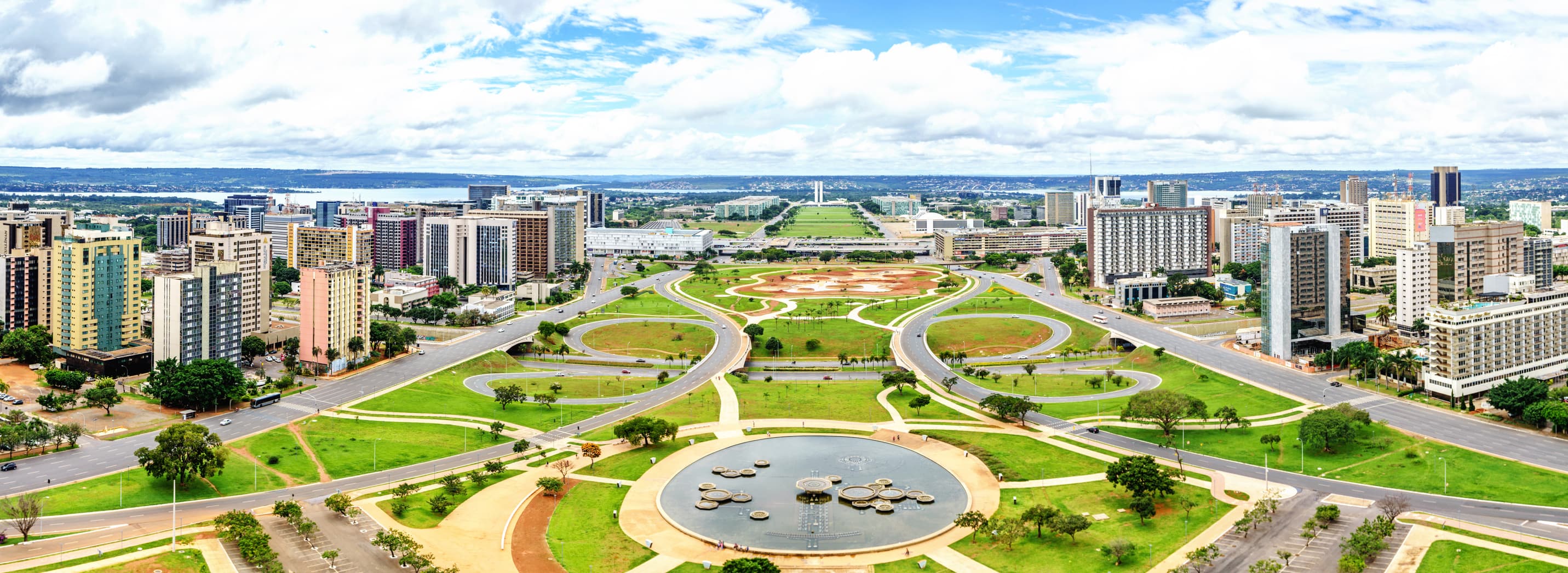 iStock-646683156 Breed luchtbeeld van Brasília met kronkelende wegen, groene zones en hoogbouw rond een centraal plein