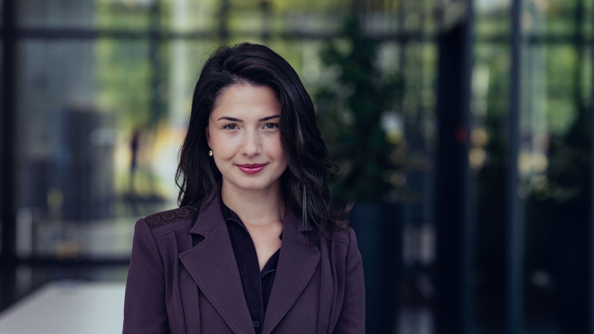 Iva%20Tchetinova-Yancheva Portrait of Iva Tchetinova-Yancheva in a purple blazer against a blurred office background