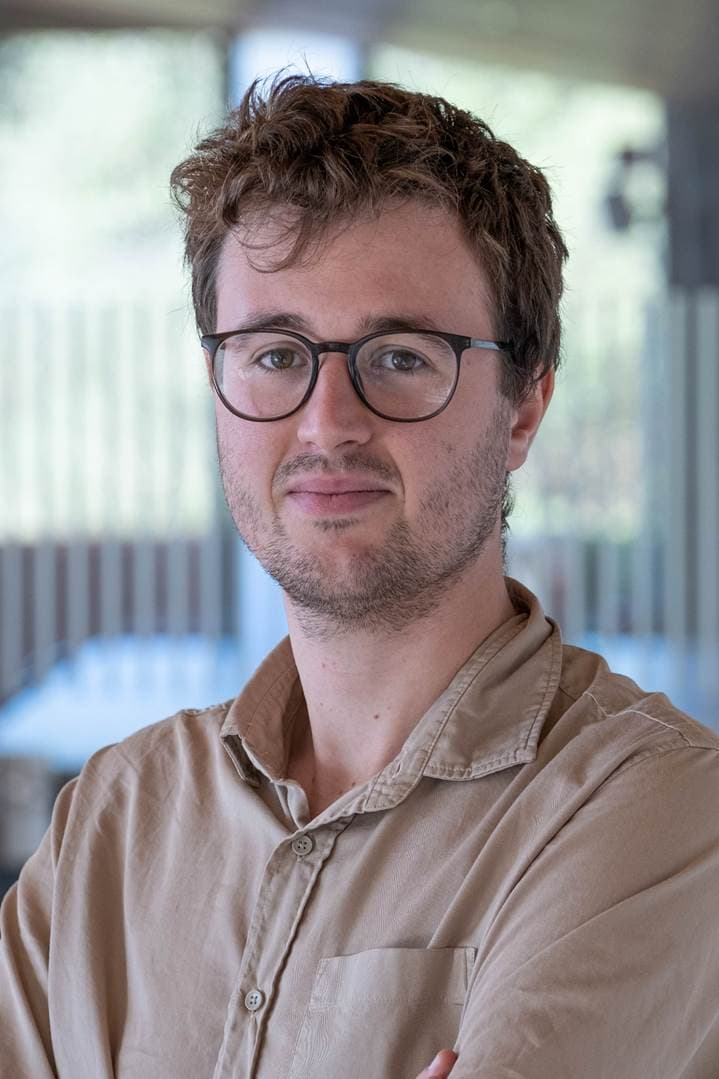 Jakob%20Declercq Portrait of Jakob Declercq, a researcher wearing glasses and a beige shirt.