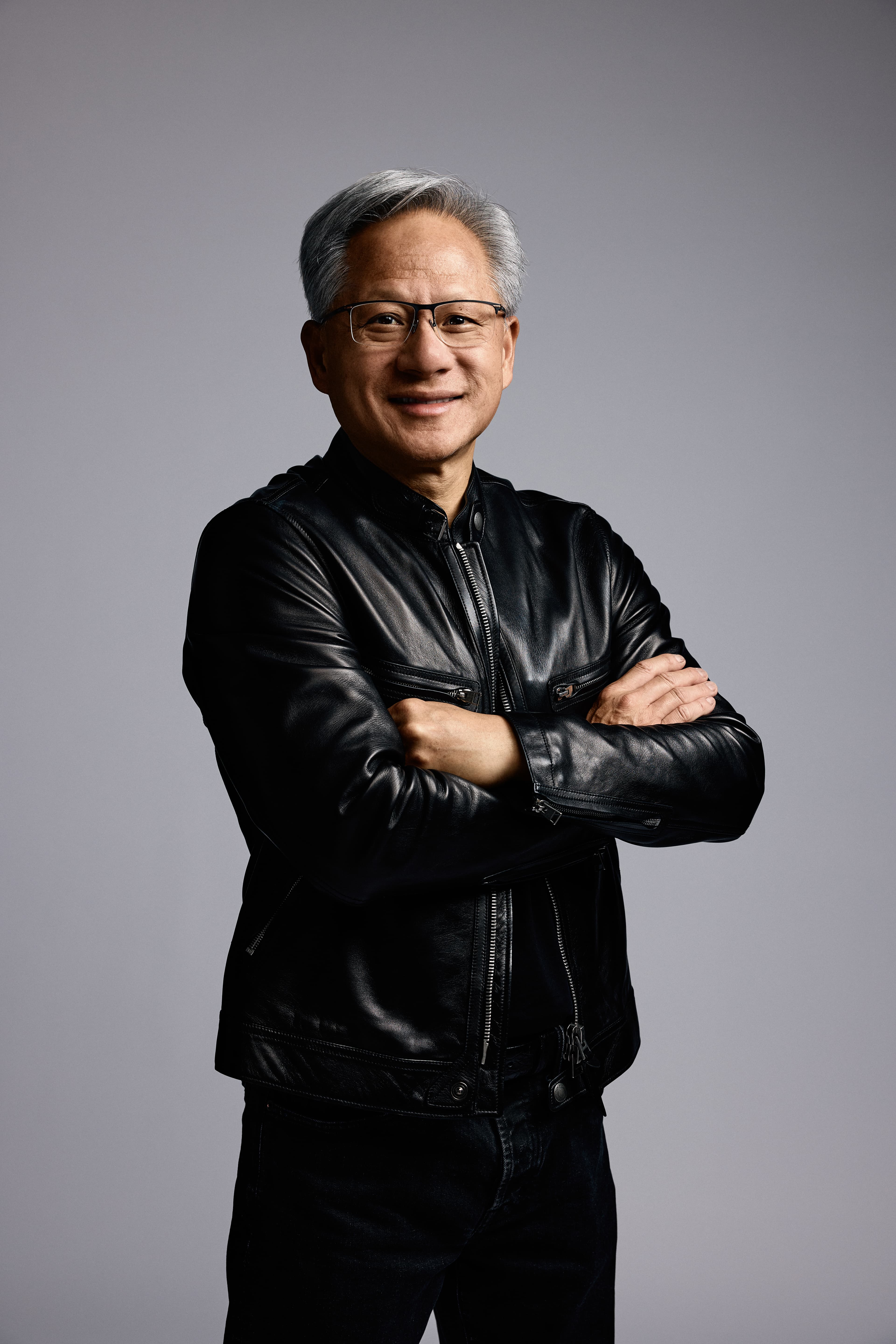jensen-huang-headshot-gray-background Portret van Jensen Huang met gekruiste armen tegen een grijze achtergrond
