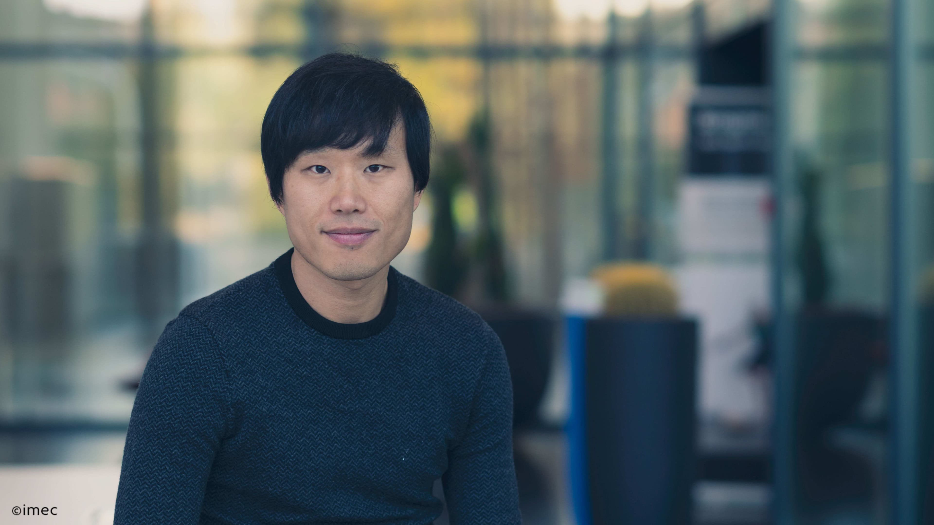 Jiwon-lee-2019-004_1mb Portrait of Jiwon Lee seated in front of a blurred laboratory background