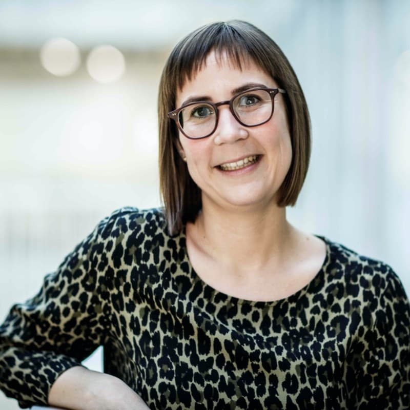 lies Portrait of Lies De Groef, smiling in glasses and a patterned top