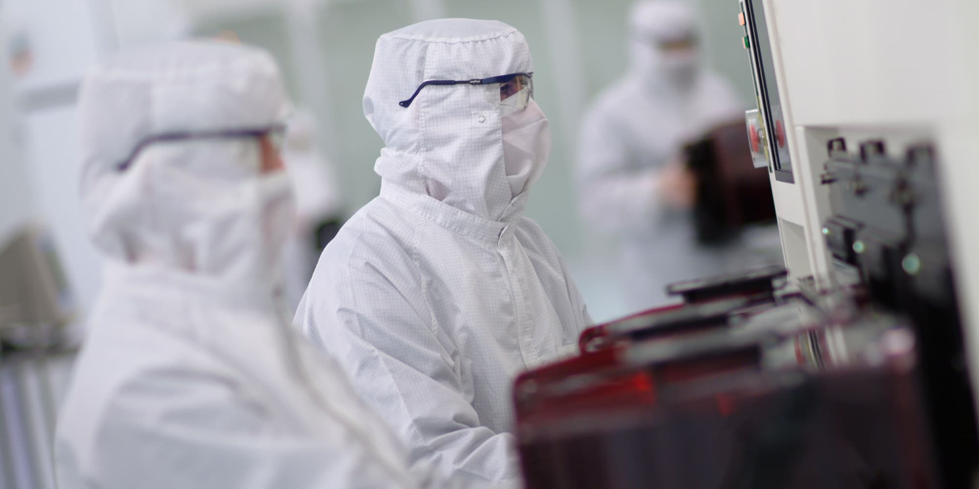 Logic-CMOS-scaling Researchers in cleanroom suits working beside semiconductor equipment