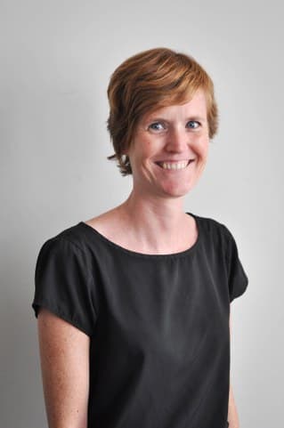 lynn_1 Portrait of Lynn Coorevits smiling against a light gray background