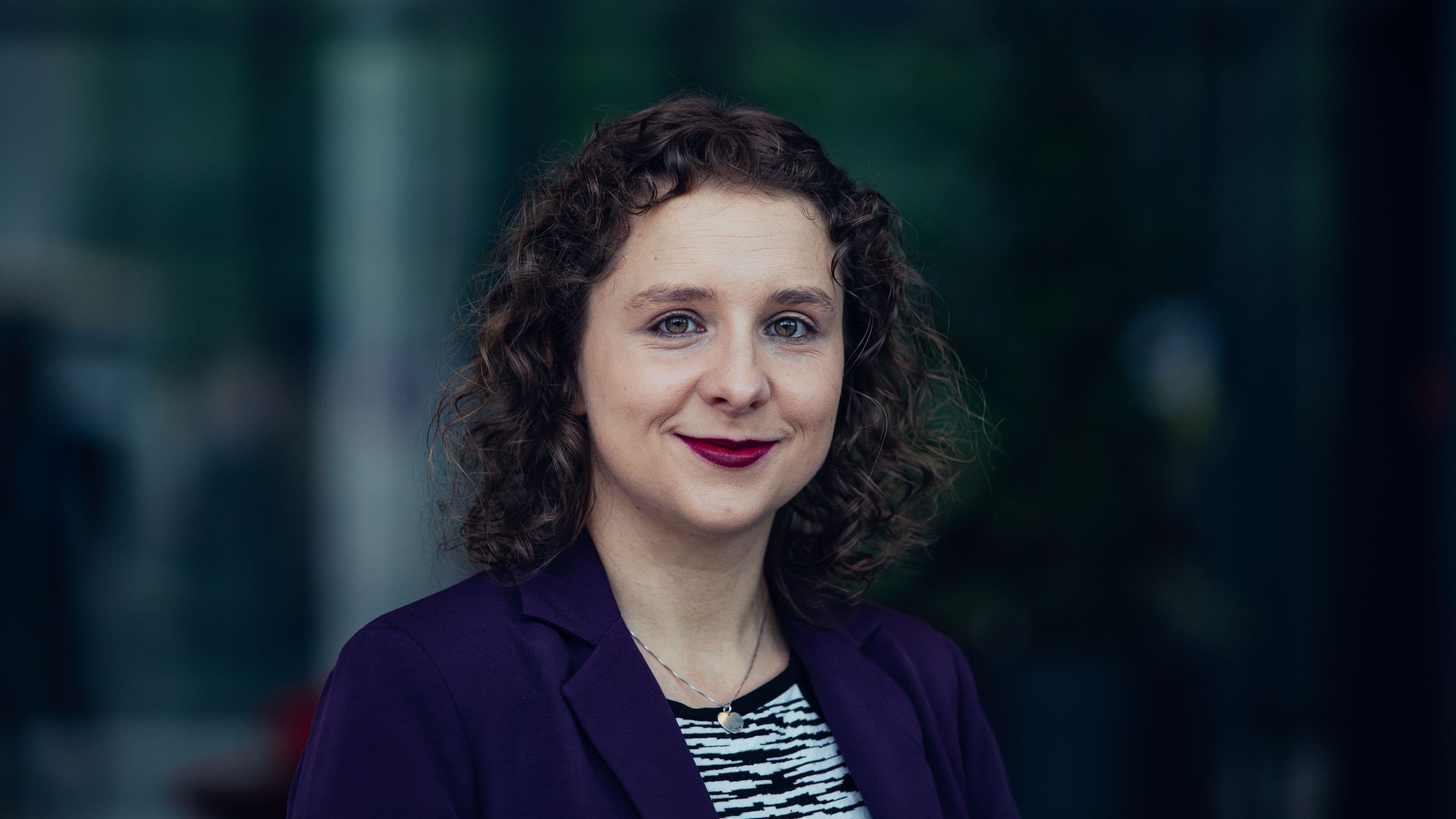 Lynn%20Verschueren Portrait of Lynn Verschueren, an imec R&D team leader, in a purple blazer against a blurred dark background