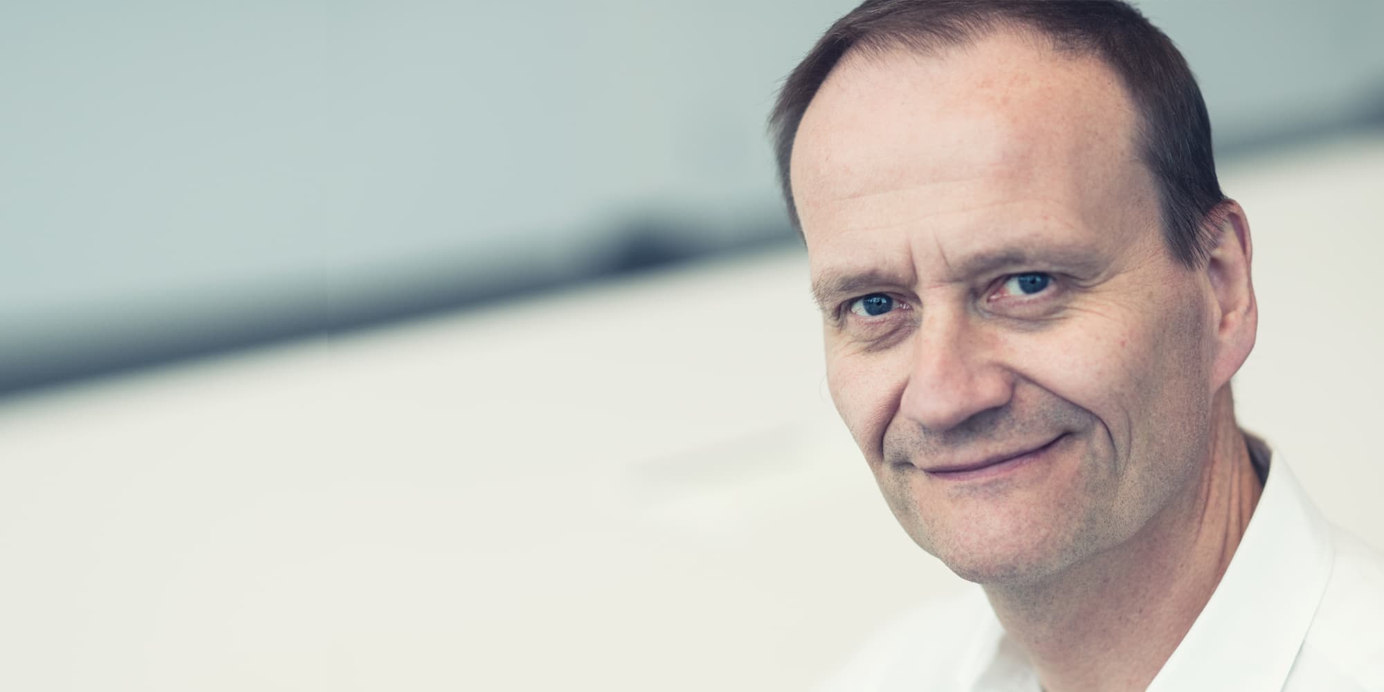 magazine-Paul-Heremans_1 Portrait of Paul Heremans in a white shirt, smiling at the camera