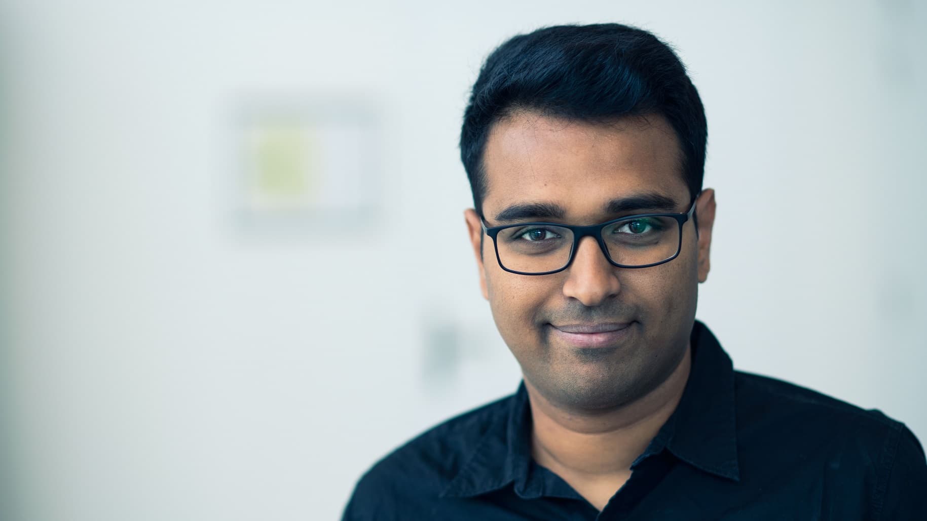Manoj.Jaysankar001_lr_1 Portrait of Manoj Jaysankar wearing glasses against a light background.