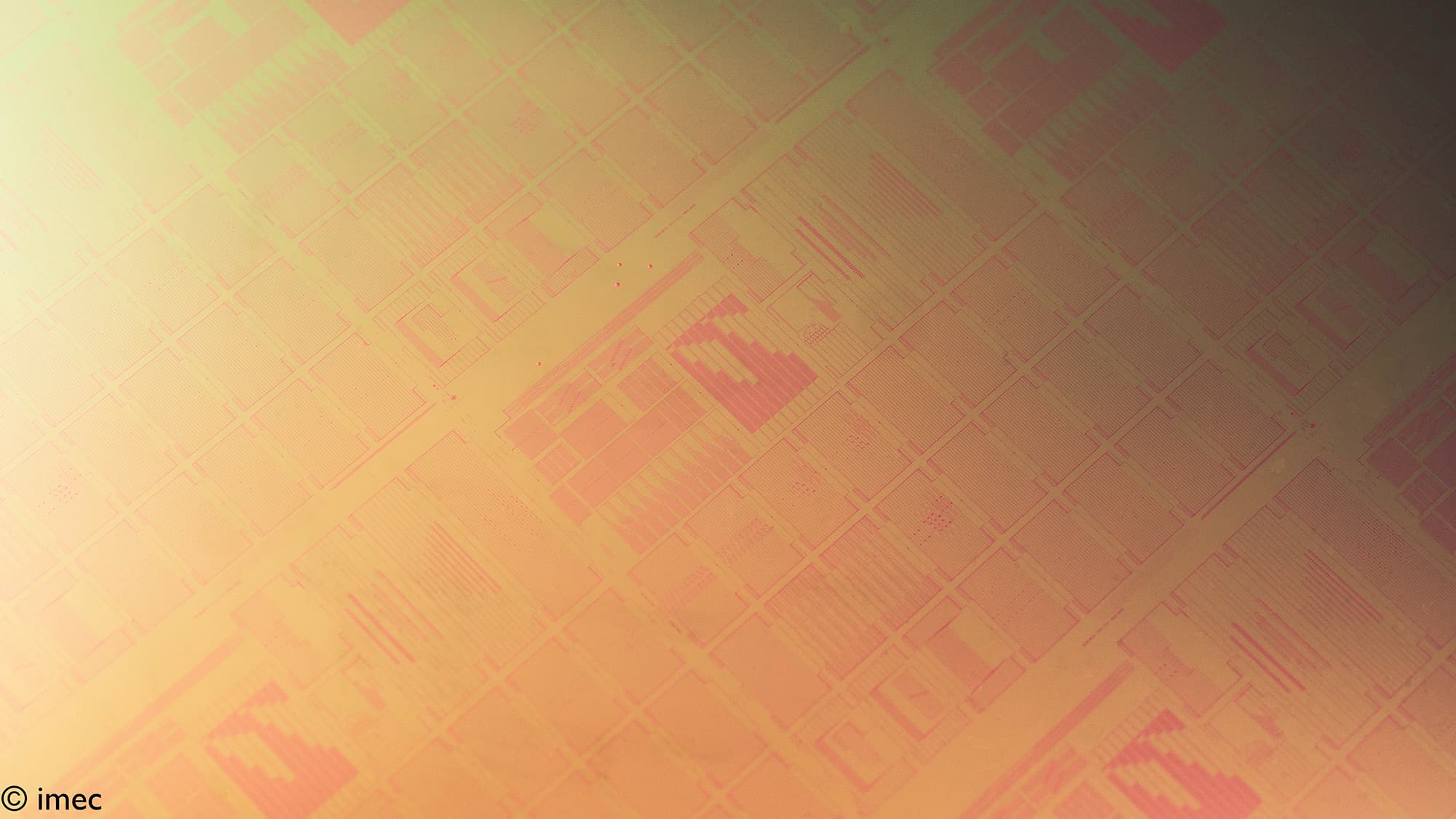Close-up of silicon wafer with microchip patterns Close-up of a silicon wafer with patterned microchip structures in warm gold and pink tones.