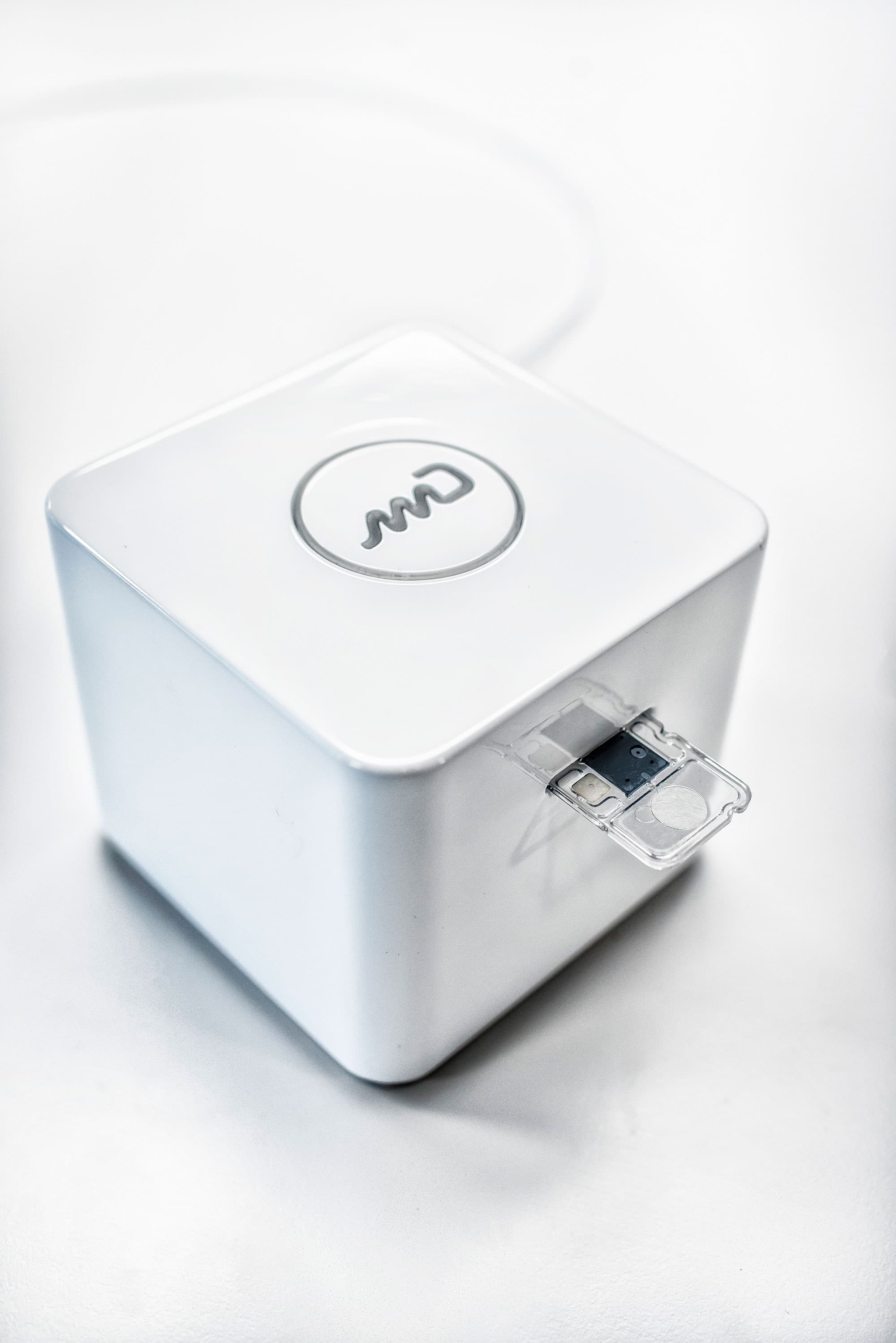 midx_1 White diagnostic device with imec logo and a small transparent cartridge protruding from the side