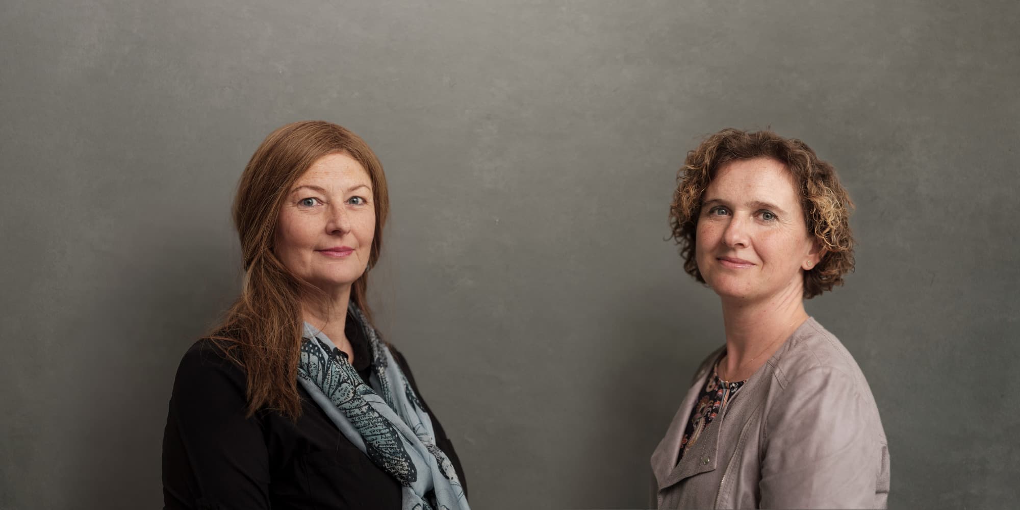 Moonshot-interview Two women posed against a gray background for a Moonshot interview portrait.
