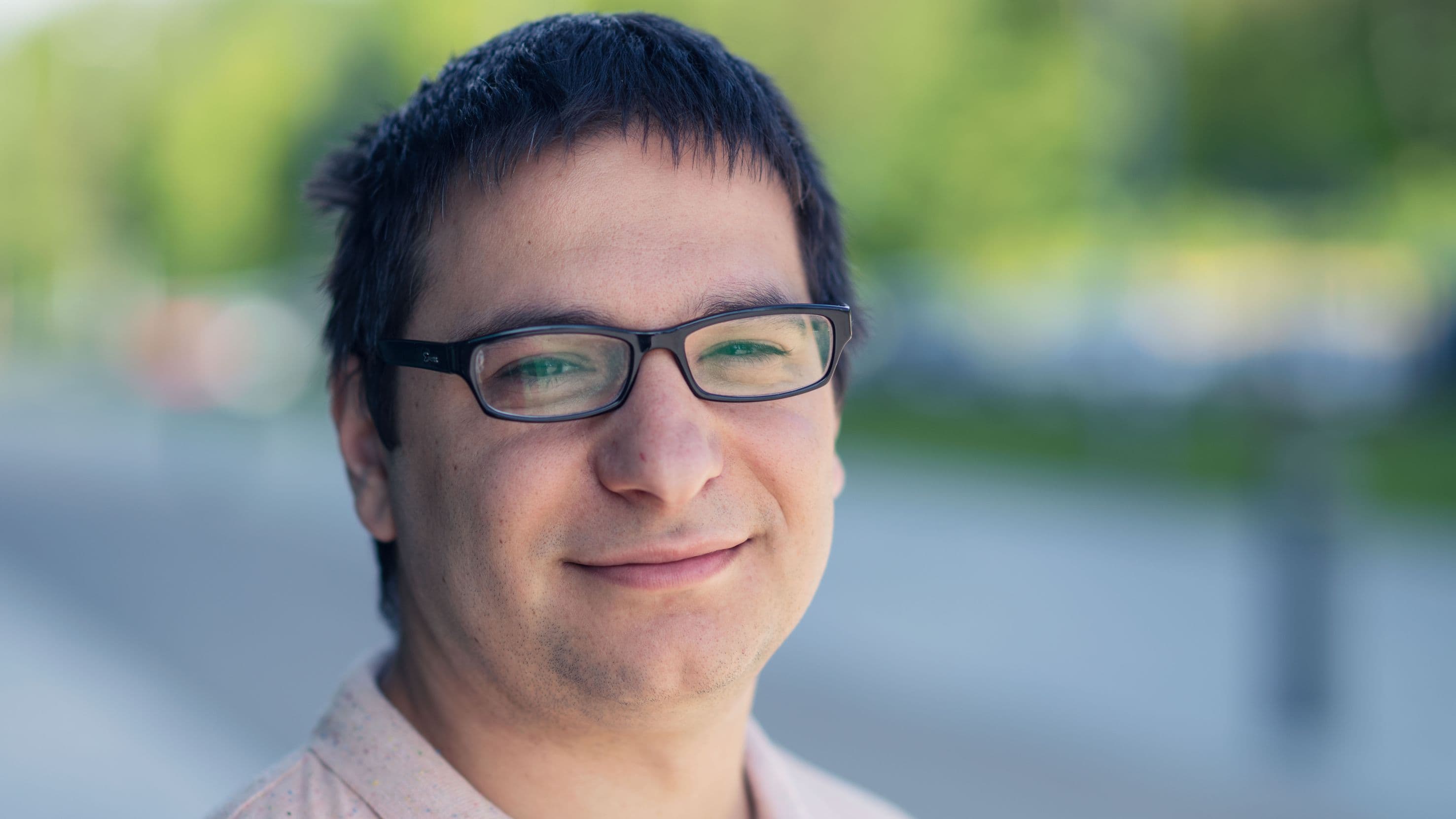 murat_pak_1 Portrait of Murat Pak wearing glasses, outdoors with a softly blurred background.