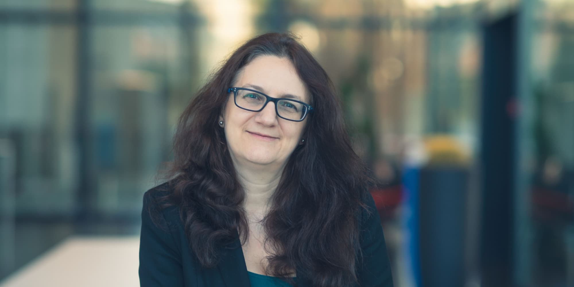 Nadine-collaerts-2000x1000 Portrait of imec fellow Nadine Collaert smiling in front of a blurred office background