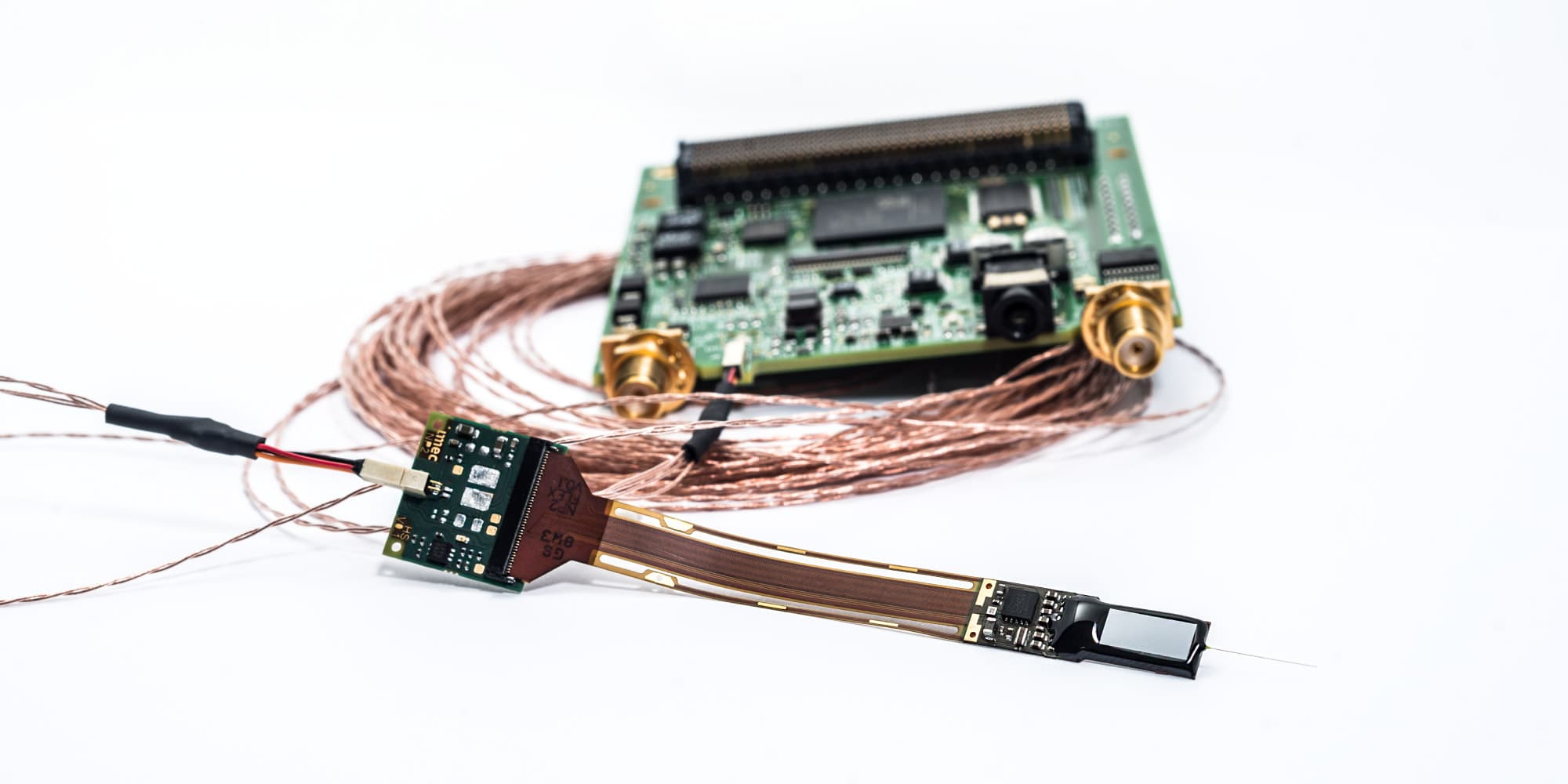 neuroprobe_1 Miniature neural probe with flexible cable connected to a circuit board and coiled copper wires