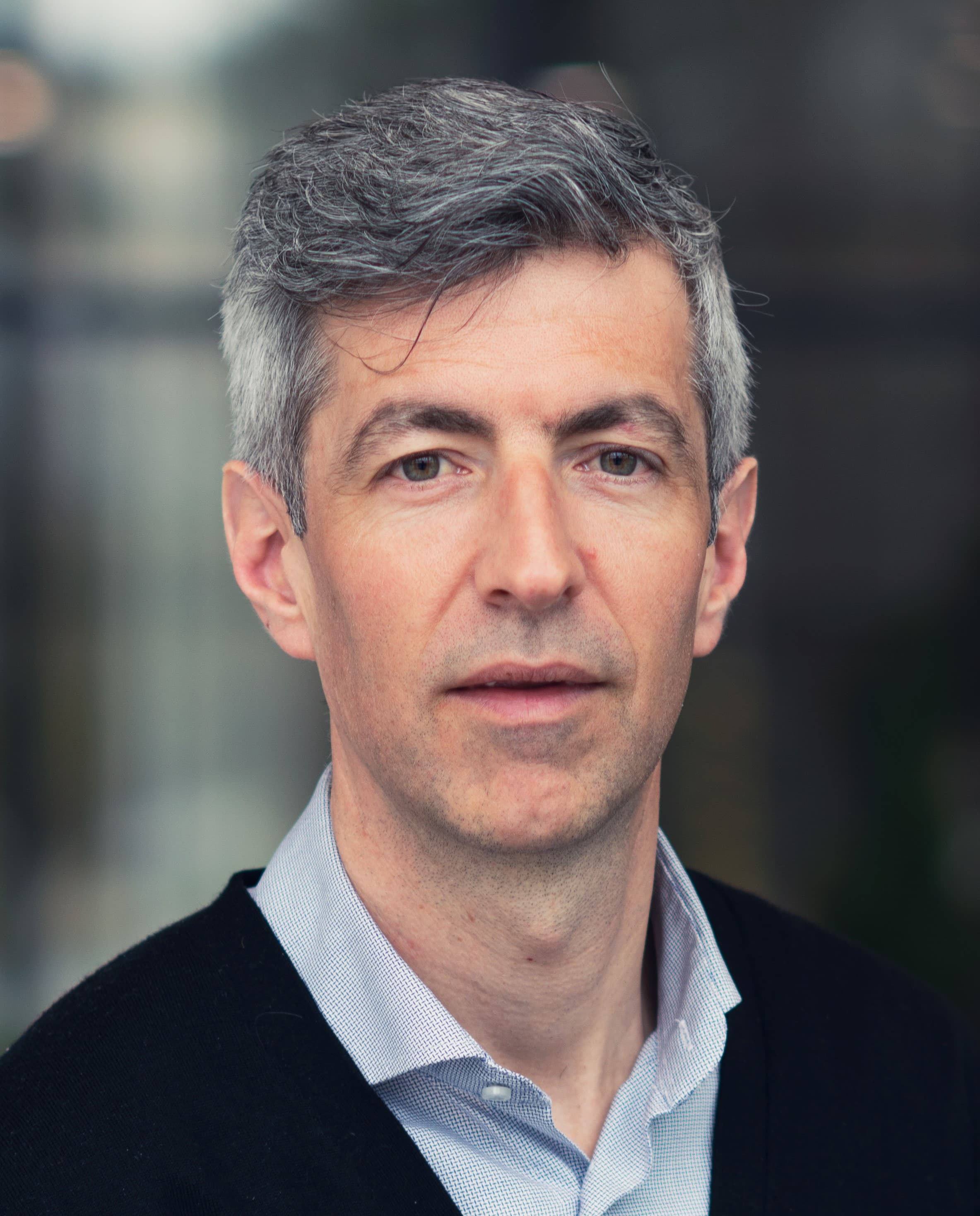 olivier_rousseaux_1 Portrait of Olivier Rousseaux in a dark sweater and light blue shirt, against a softly blurred background.