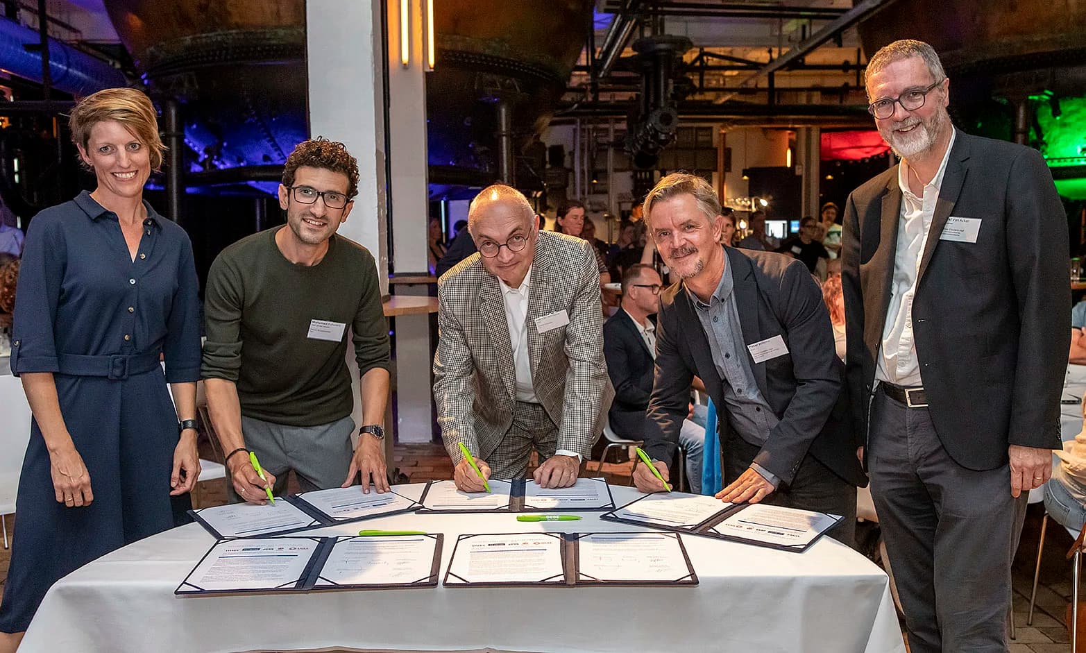 ondertekening%20intentieverklaring%20%28vlnr%20Katrien%20Rycken%2C%20burgemeester%20Mohamed%20Ridouani%-0735dcb0d181 Vijf functionarissen ondertekenen een overeenkomst aan een tafel tijdens een plechtige ceremonie.
