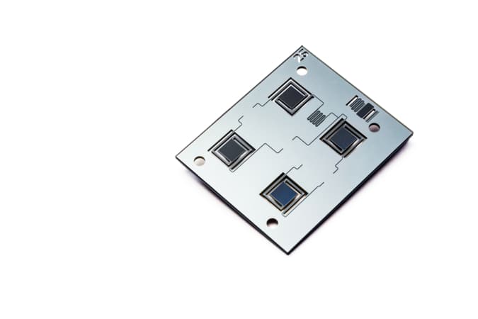 Microfluidic chip with sensor windows Microfluidic chip with four square sensor windows on a white background
