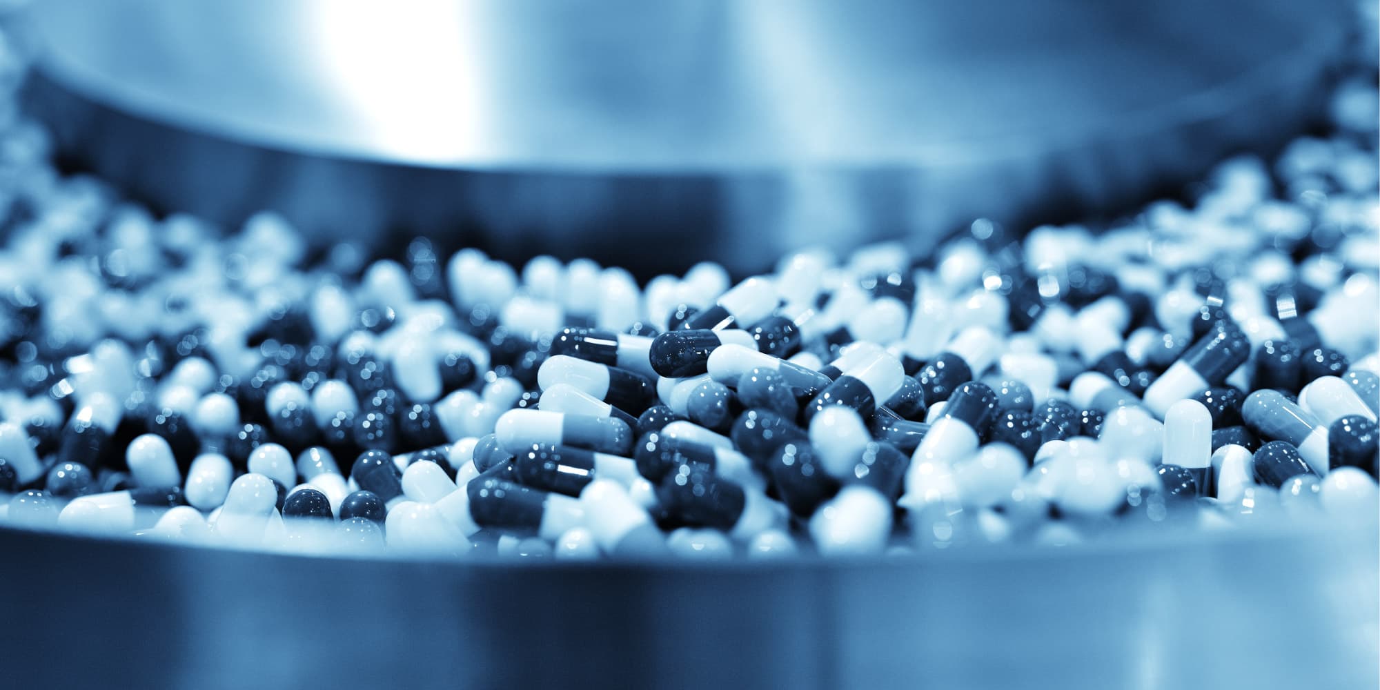 Pharma-and-nanoelectronics--a-growing-love-story Close-up of black and white capsules in a metal processing bowl