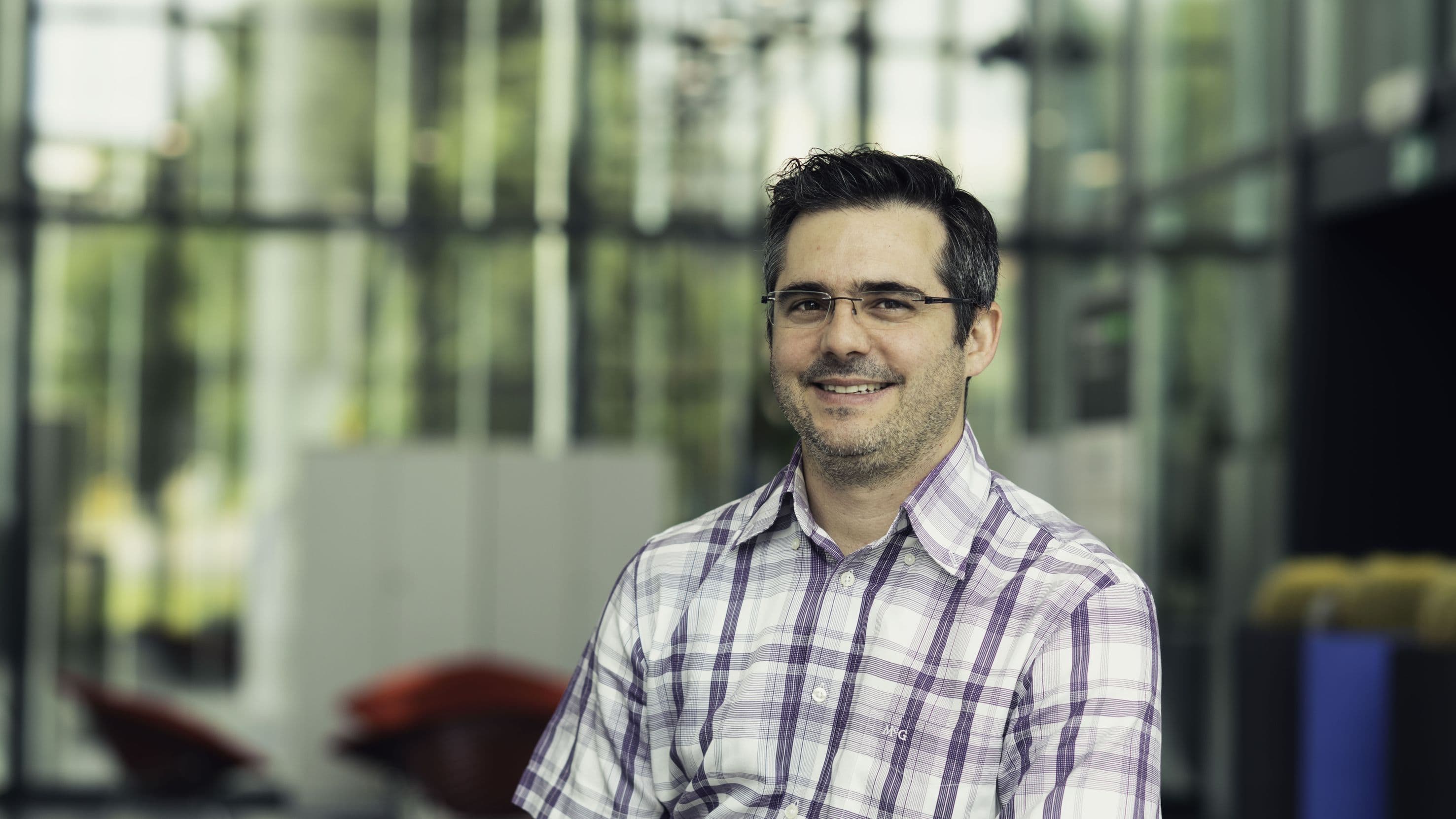philippe_soussan_1 Portrait of Philippe Soussan smiling in a glass-walled lab setting