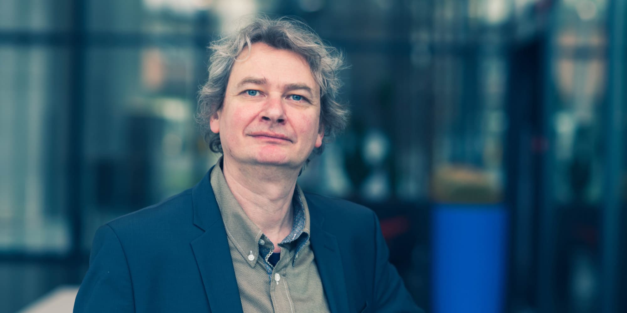 Philippe_Vereecken Portrait of Philippe Vereecken in a blue blazer against a blurred indoor background