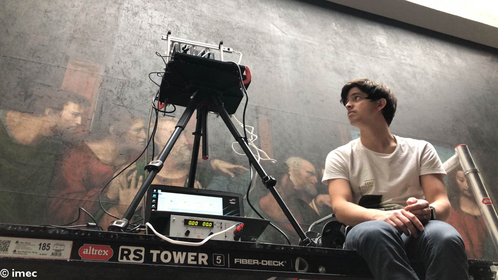 photo-2019-05-02-09-34-16_1 Researcher using a hyperspectral camera setup to scan a large painting on a scaffold platform