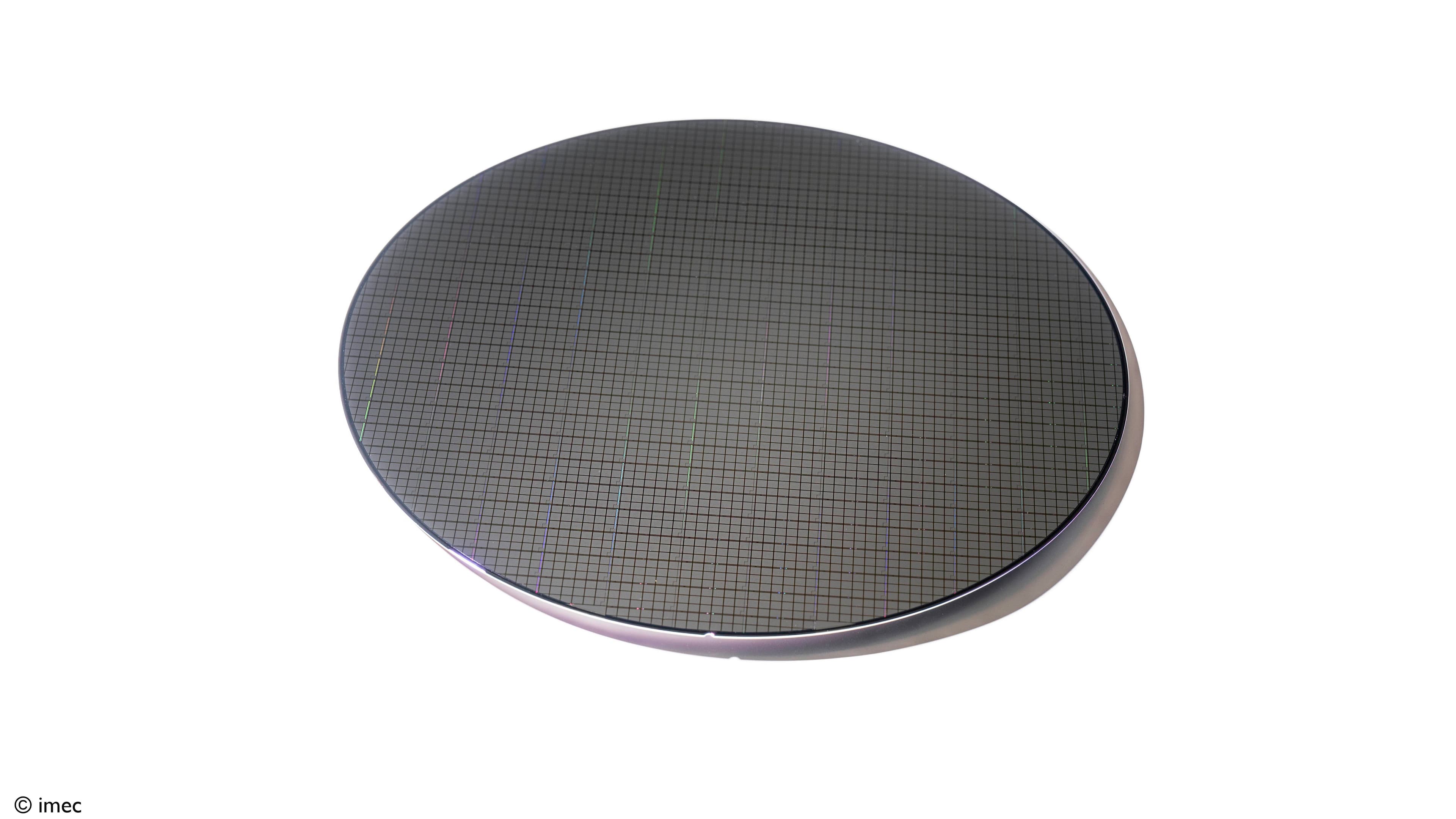 Picture%201_Imec%20pioneers%20full%20wafer-scale%20%28300mm%29%20production%20of%20solid-state%20nanopores%20with%20EUV%20lithography%2C%20as%20shown%20on%20photo Silicon wafer covered in a fine grid pattern, showing wafer-scale chip fabrication