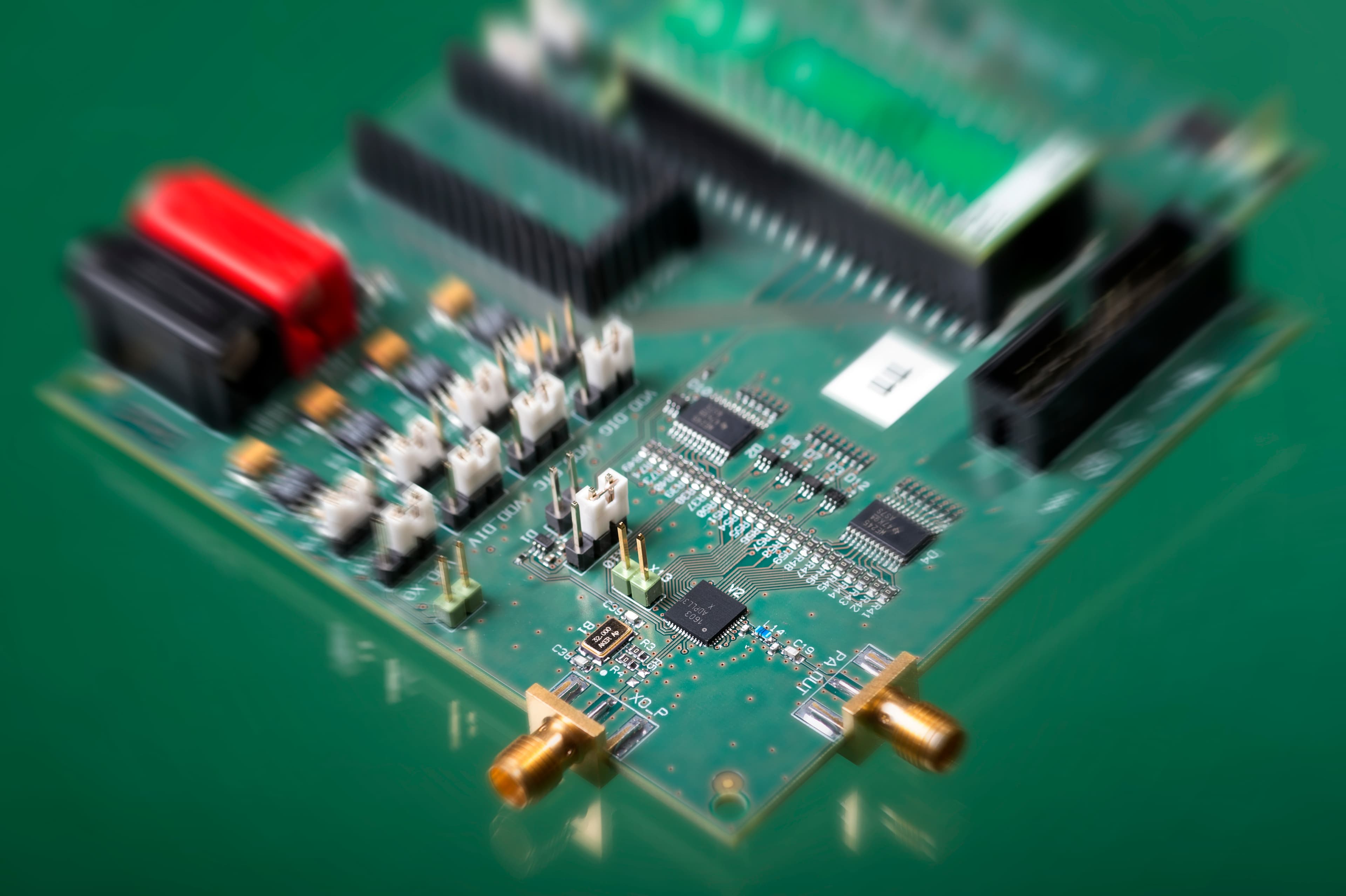 Evaluation PCB for imec ADPLL Evaluation PCB for imec’s ADPLL with connectors, chips and pin headers on a green board